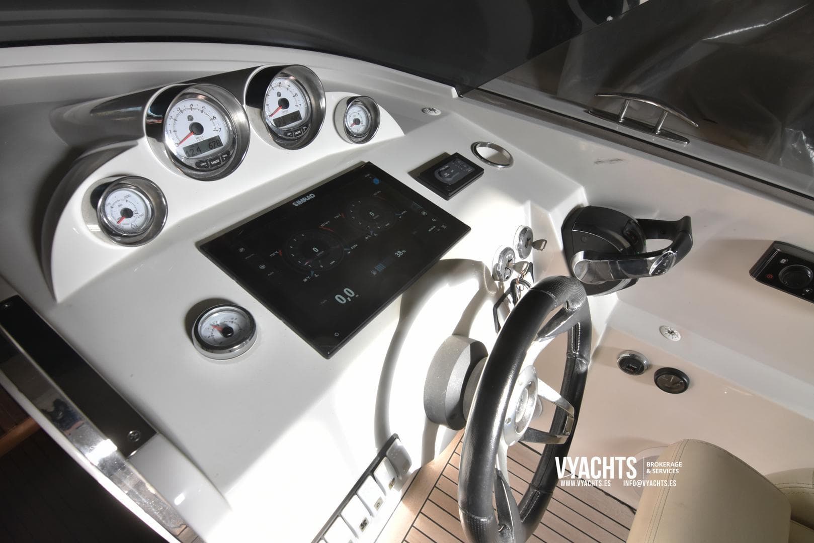 Dashboard of 2011 Frauscher 1017 GT yacht with gauges and steering wheel.