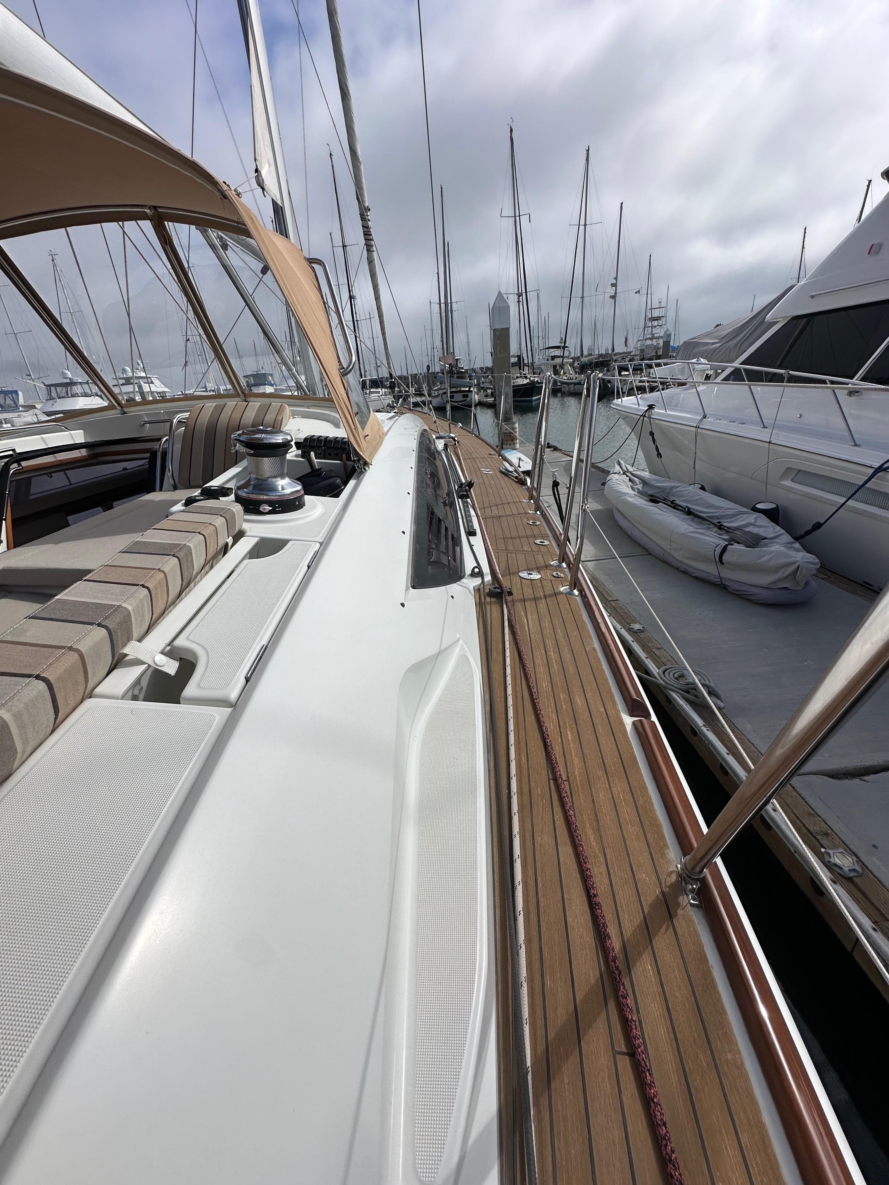 2014 Jeanneau 57 yacht docked at marina, showcasing sleek deck design and luxurious seating.