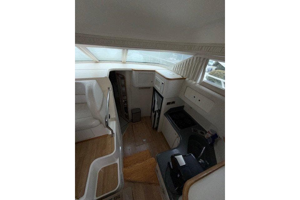 Interior of 1997 Sea Ray 400 Sedan Bridge yacht, featuring kitchen and seating area.