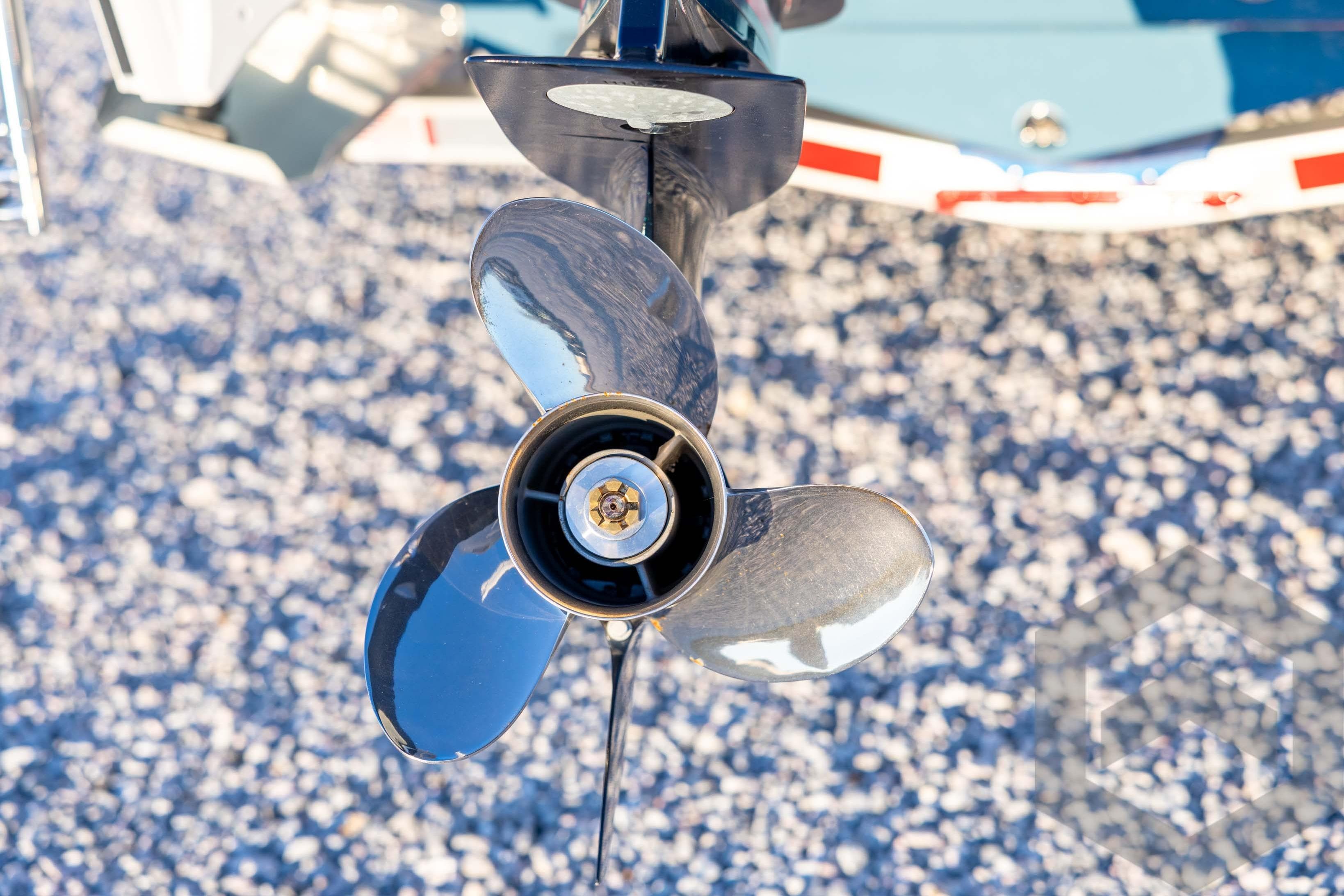 Close-up of a 2026 Tidewater 2110 Bay Max boat propeller on gravel.