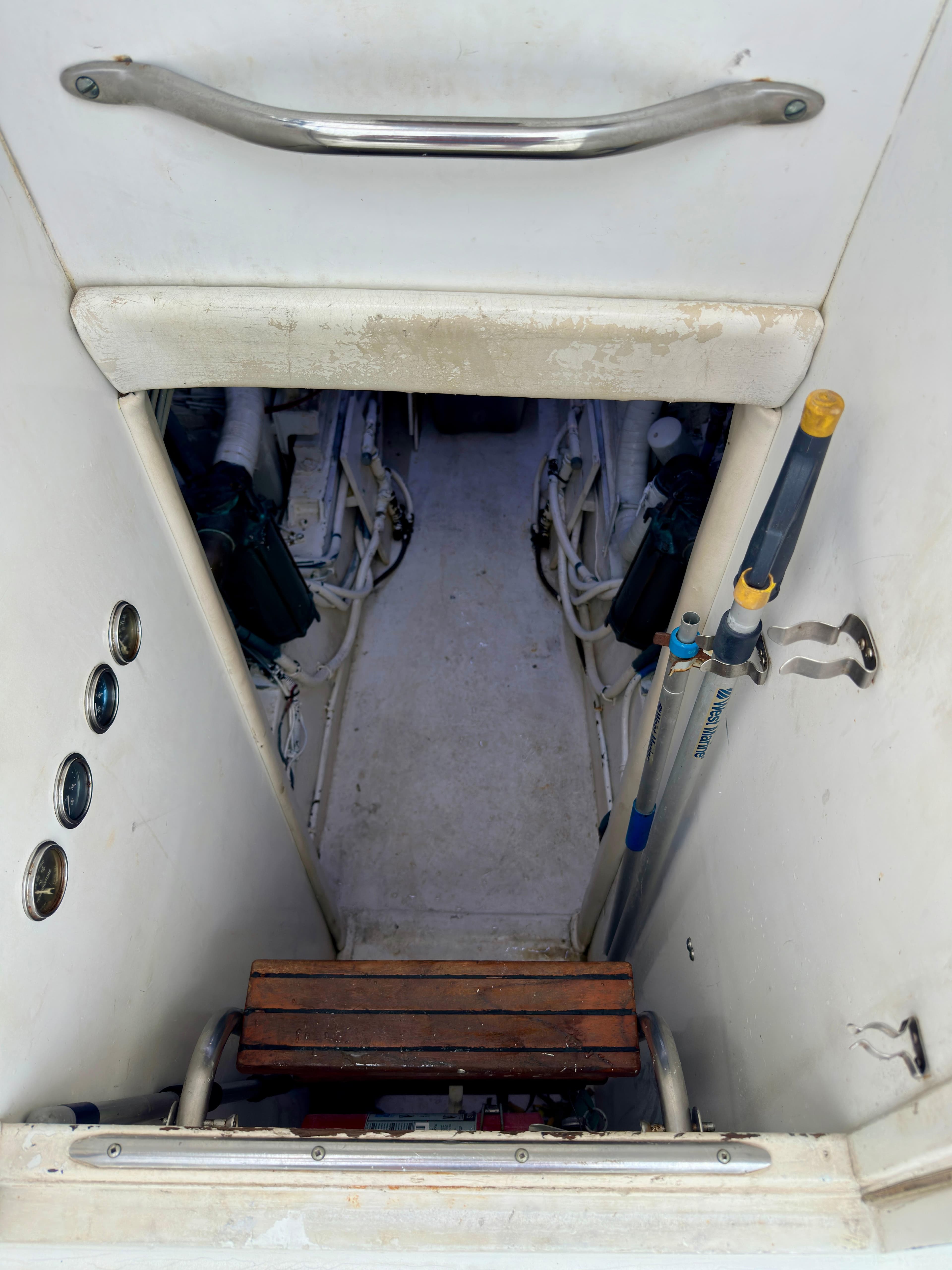 Engine room access on 1994 Hatteras 46 Convertible yacht, featuring steps and equipment storage.