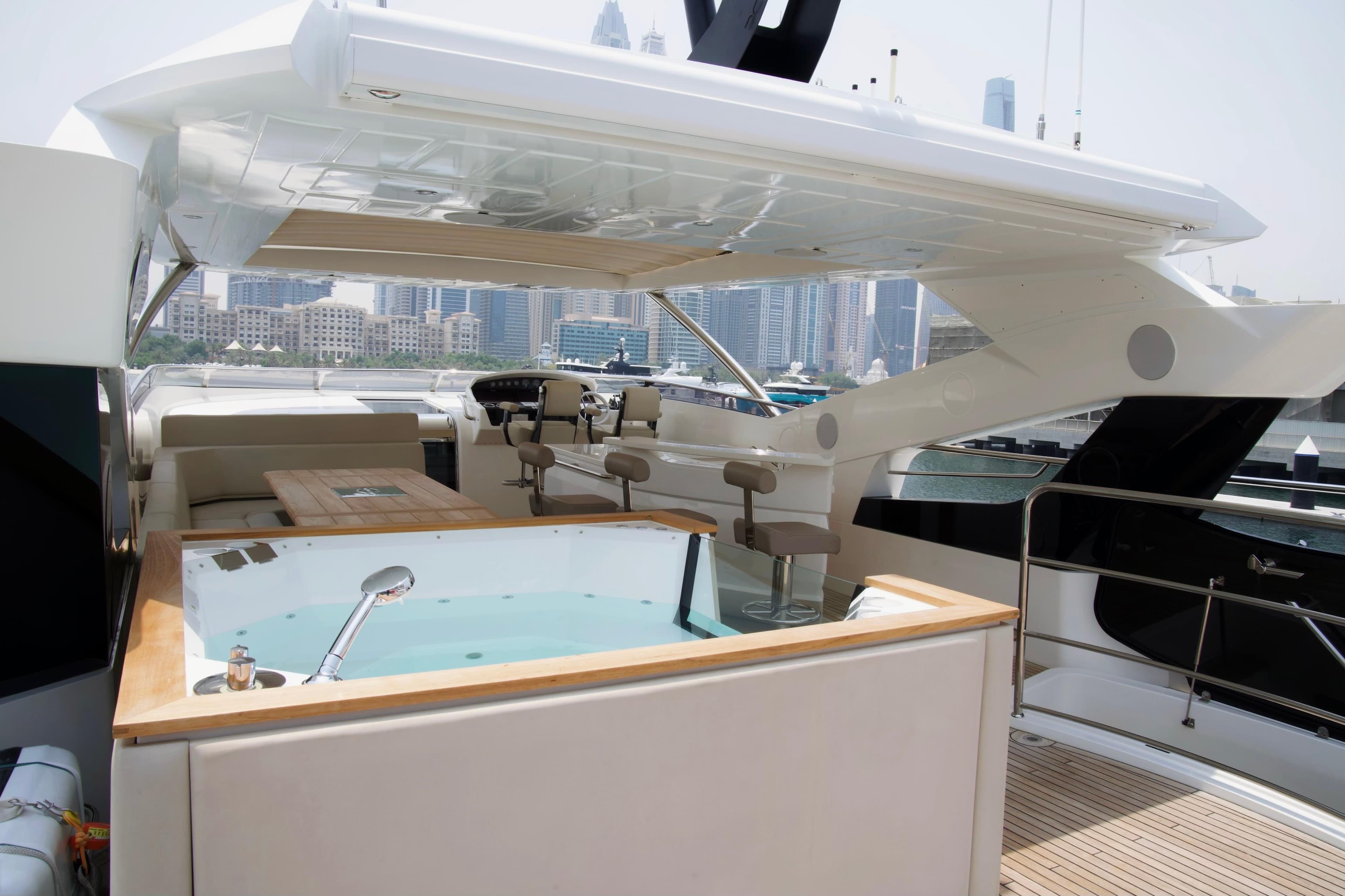 Luxurious 2018 Sunseeker 95 Yacht with jacuzzi and city skyline view.