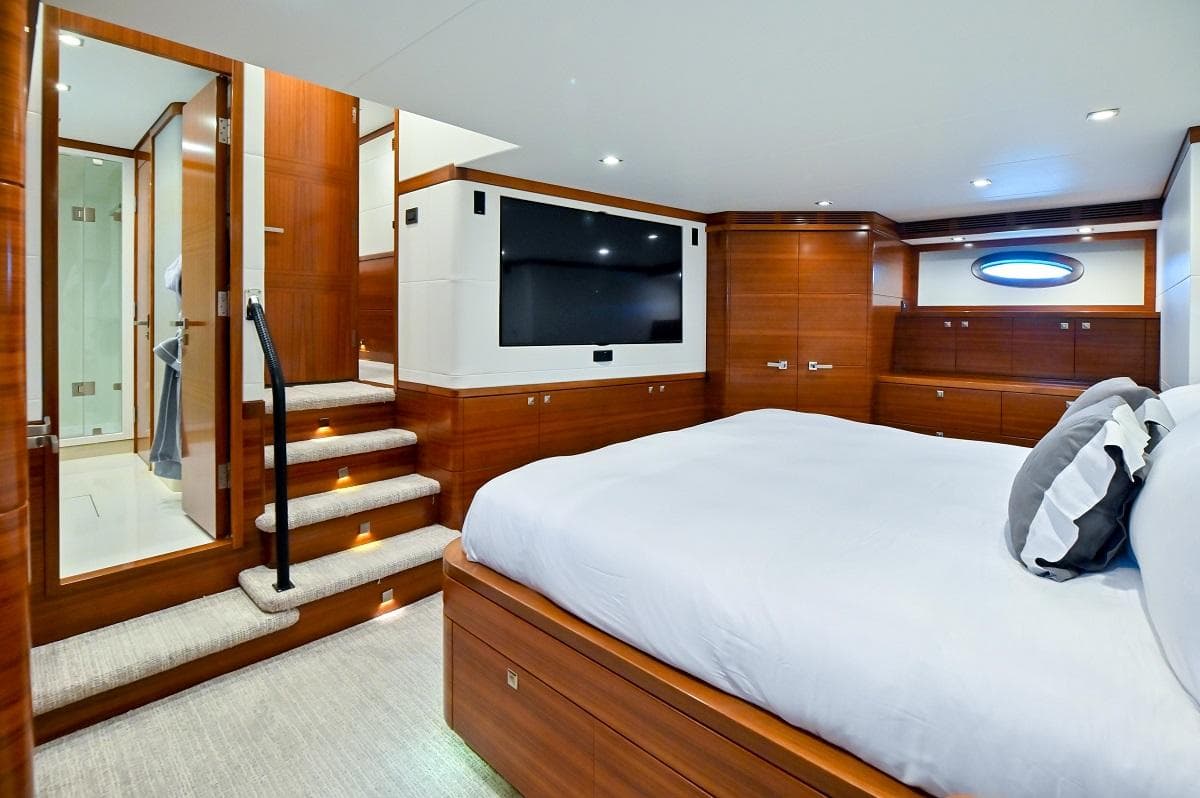 Luxurious bedroom interior of 2013 Sea Force IX 94' Sportfisher yacht with wood paneling and modern amenities.