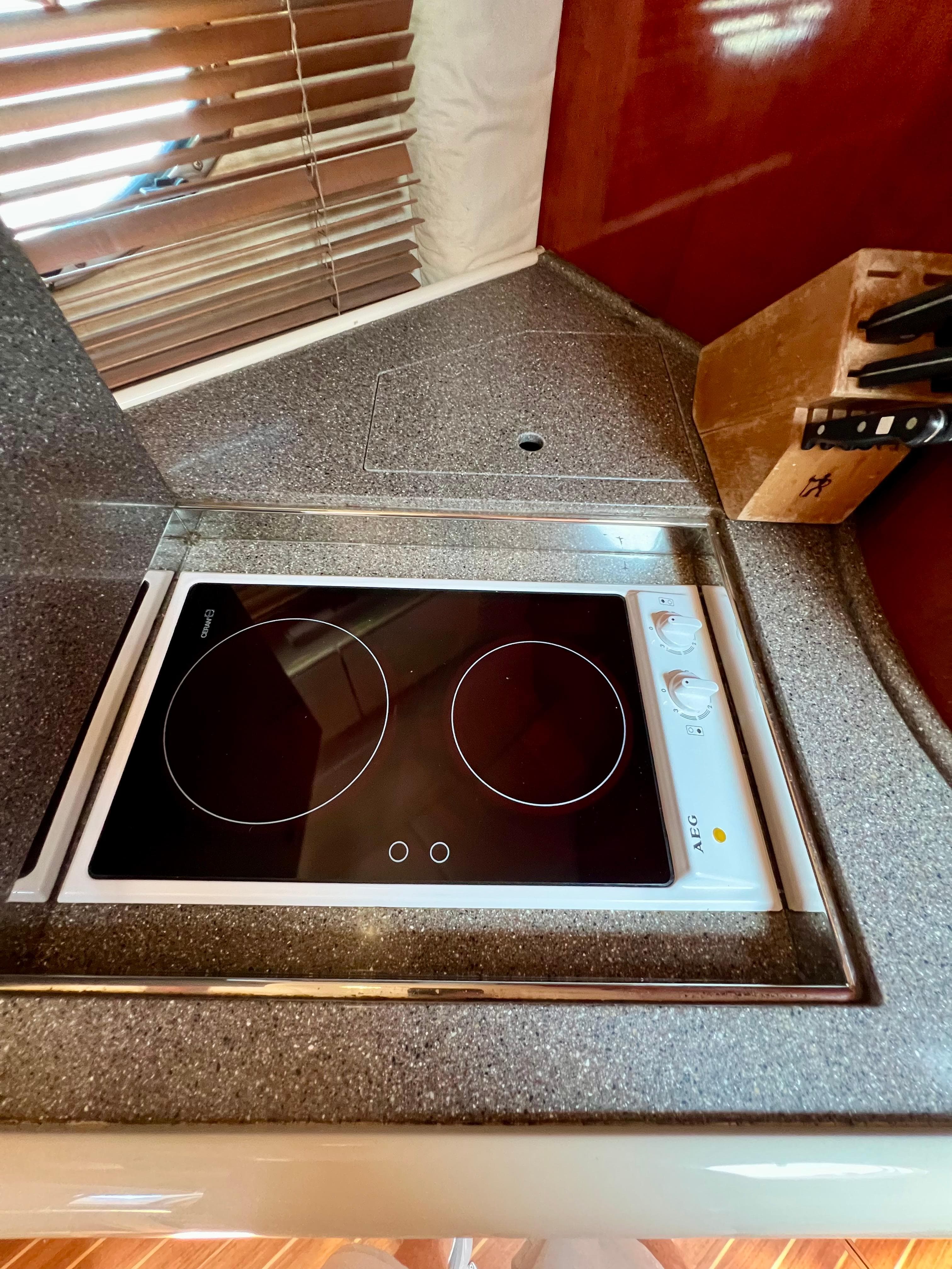 1999 Fairline Targa 48 Open yacht kitchen with modern stovetop and knife set.
