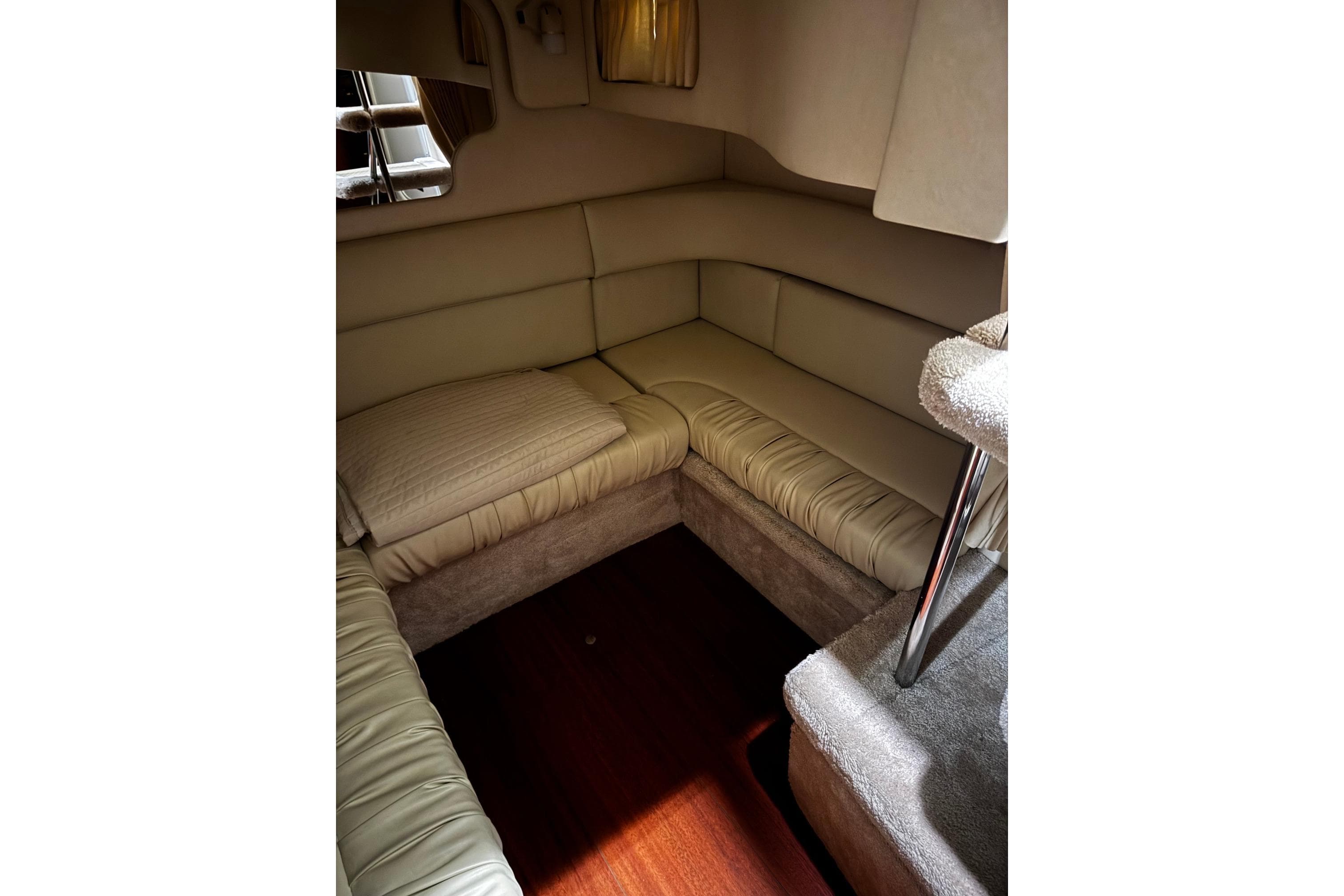Interior of 1999 Sea Ray 340 Sundancer with beige seating and wooden flooring.