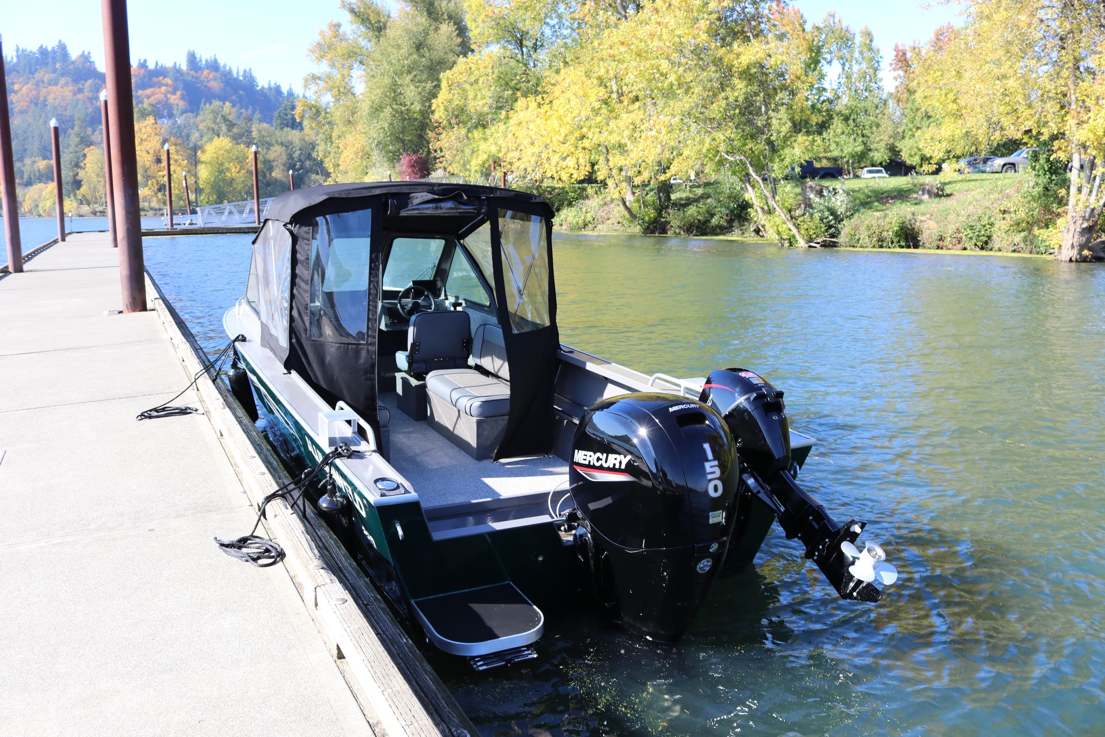 2026 Alumaweld Stryker 220 boat docked on a scenic river with Mercury engine.