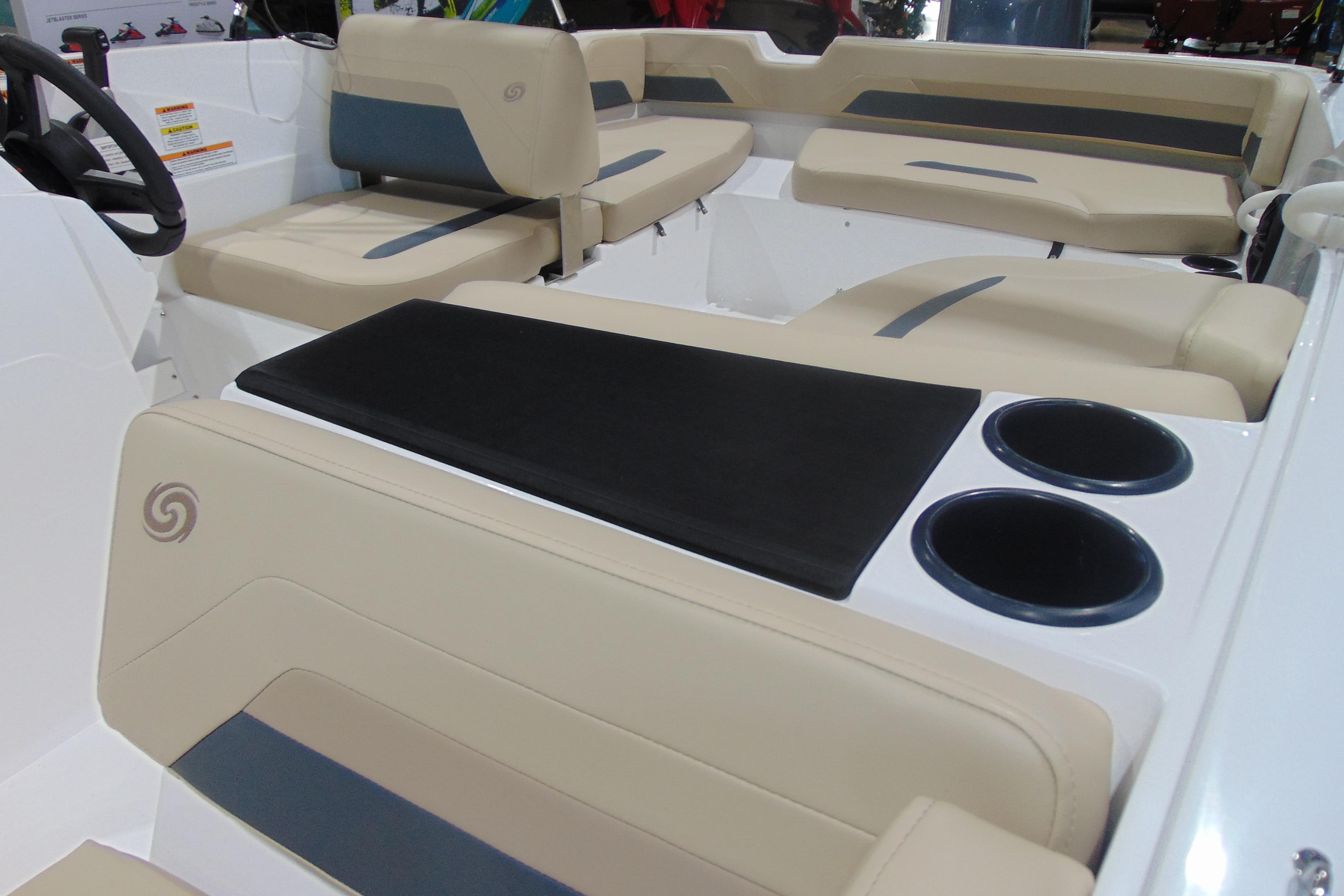 2026 Hurricane SunDeck Sport 185 OB boat interior with beige seating and cup holders.