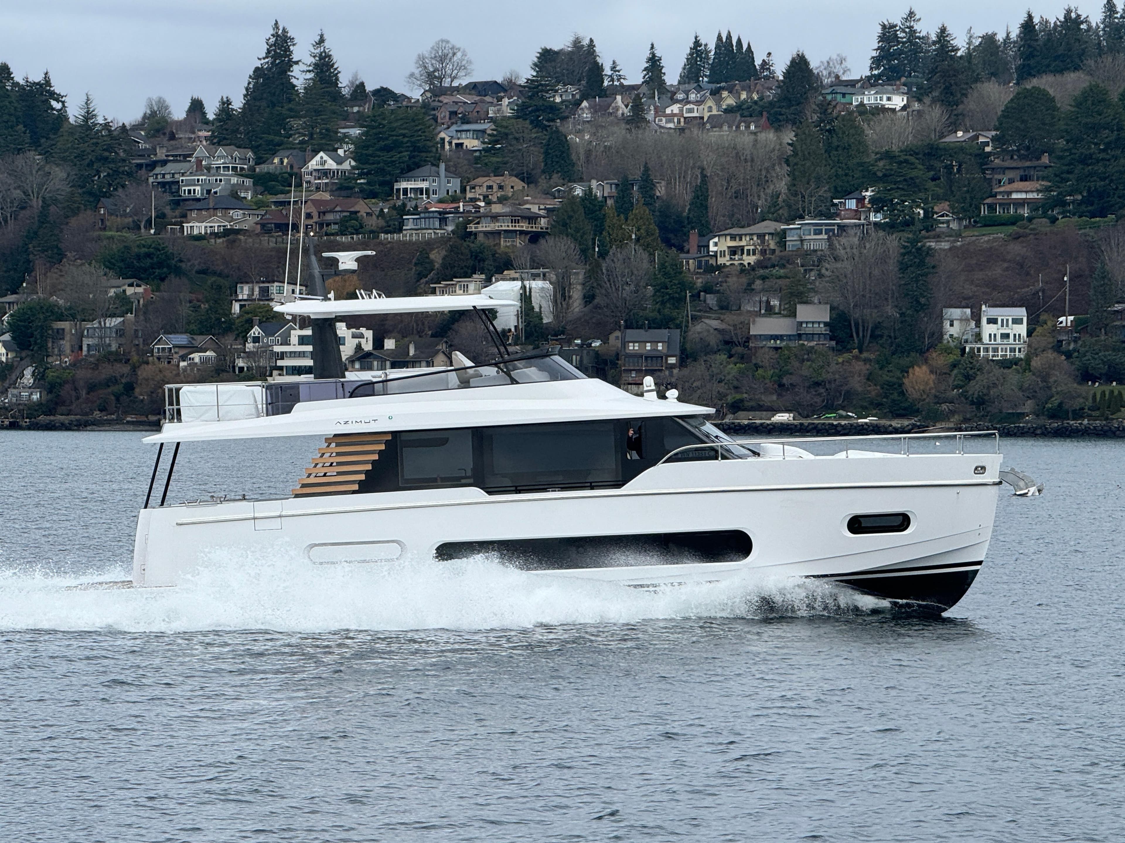 2025 Azimut Magellano 60 yacht cruising on a scenic lake.
