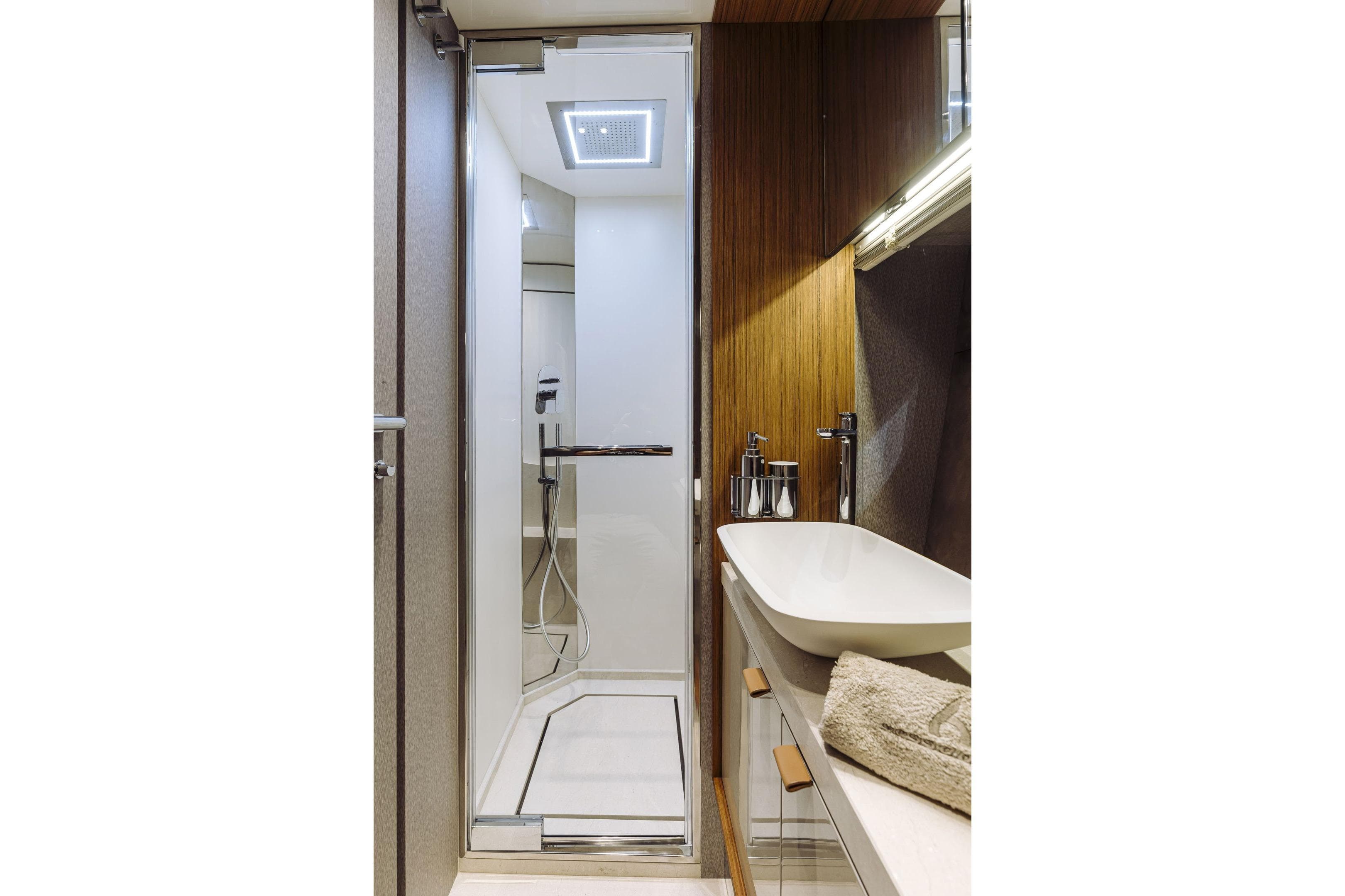 Luxurious bathroom in 2026 Cranchi Sessantadue 62 yacht with modern shower and sleek sink.