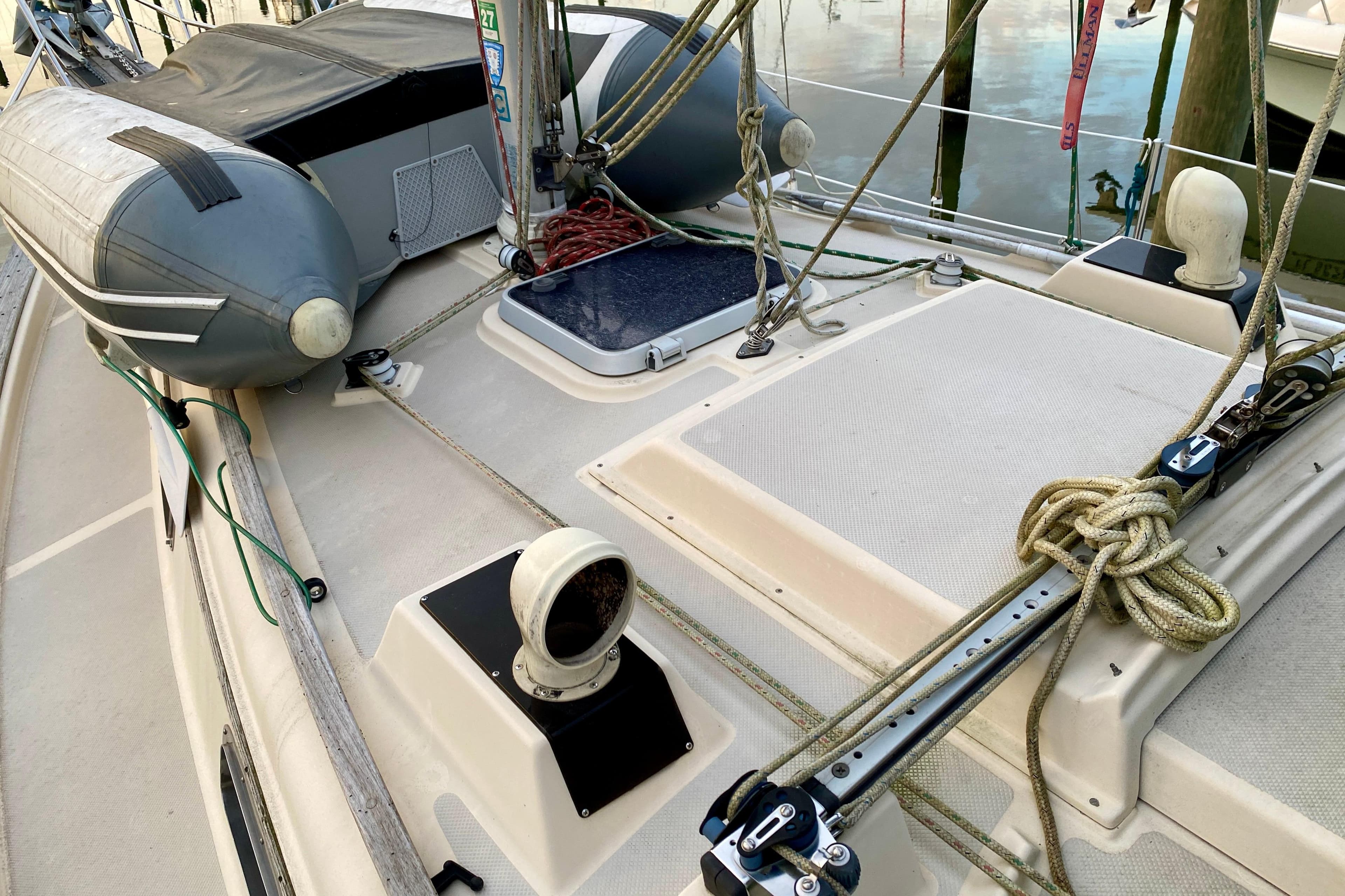 Deck of 1992 Island Packet 29 sailboat with ropes and inflatable dinghy.