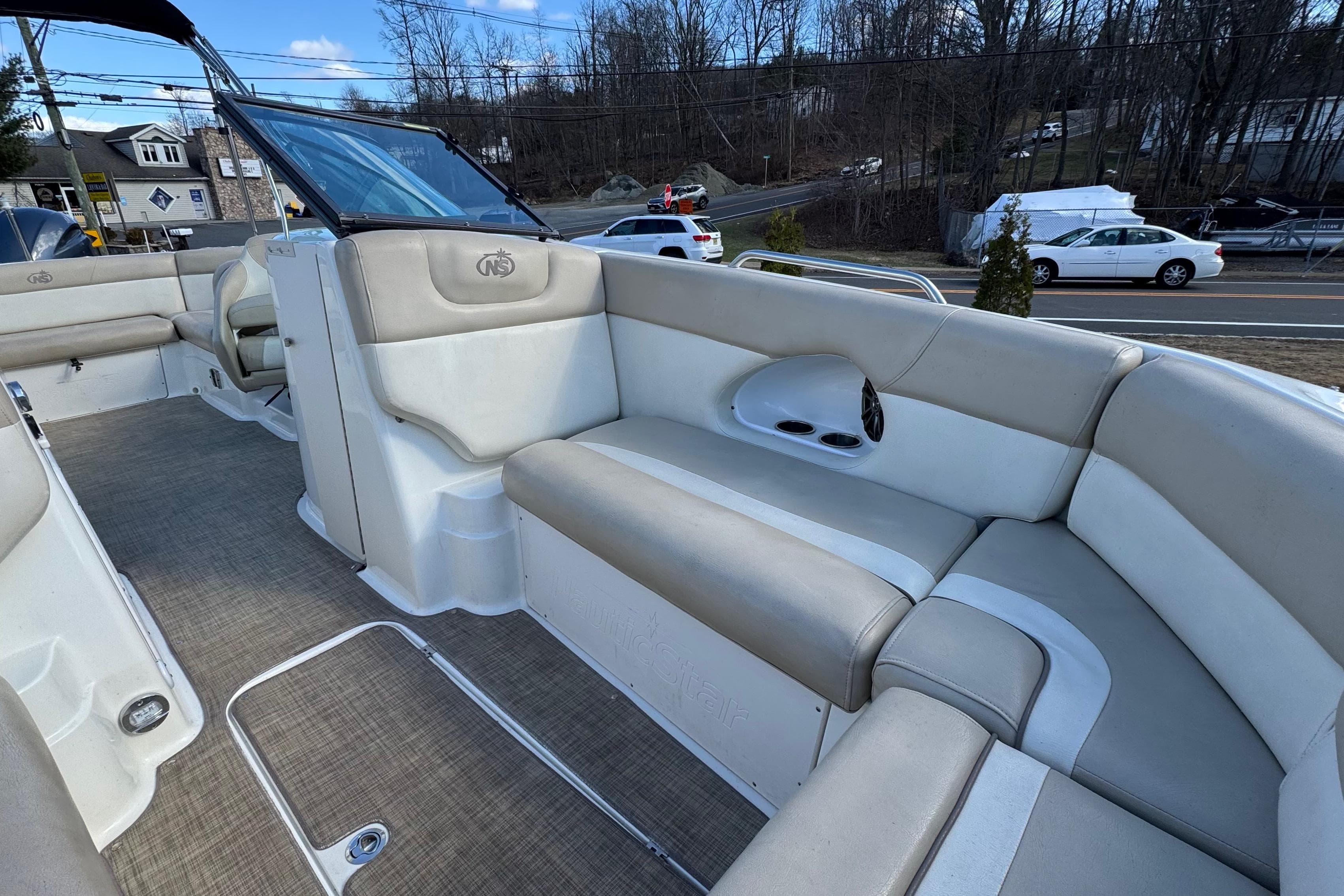 2017 NauticStar 243DC Sport Deck boat interior with beige seating and open deck layout.