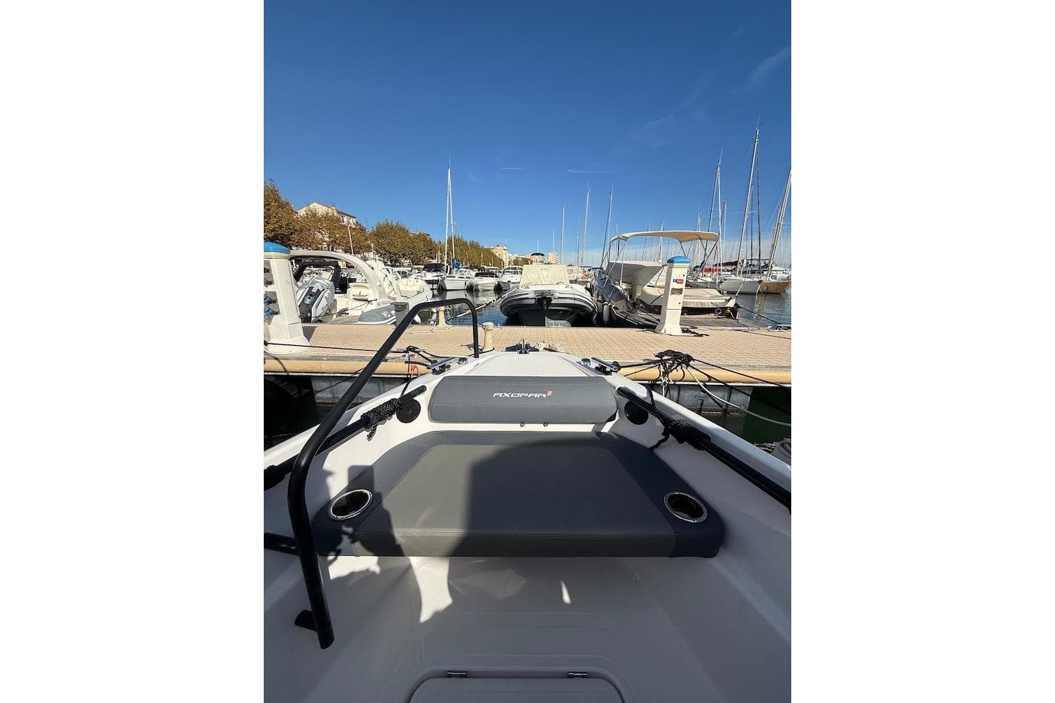 2022 Axopar 22 T-Top boat docked at a marina under clear blue skies.