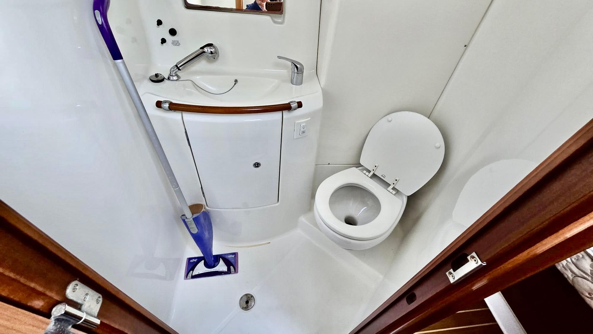 Compact bathroom in 2006 Beneteau 393 yacht with sink, toilet, and mirror.