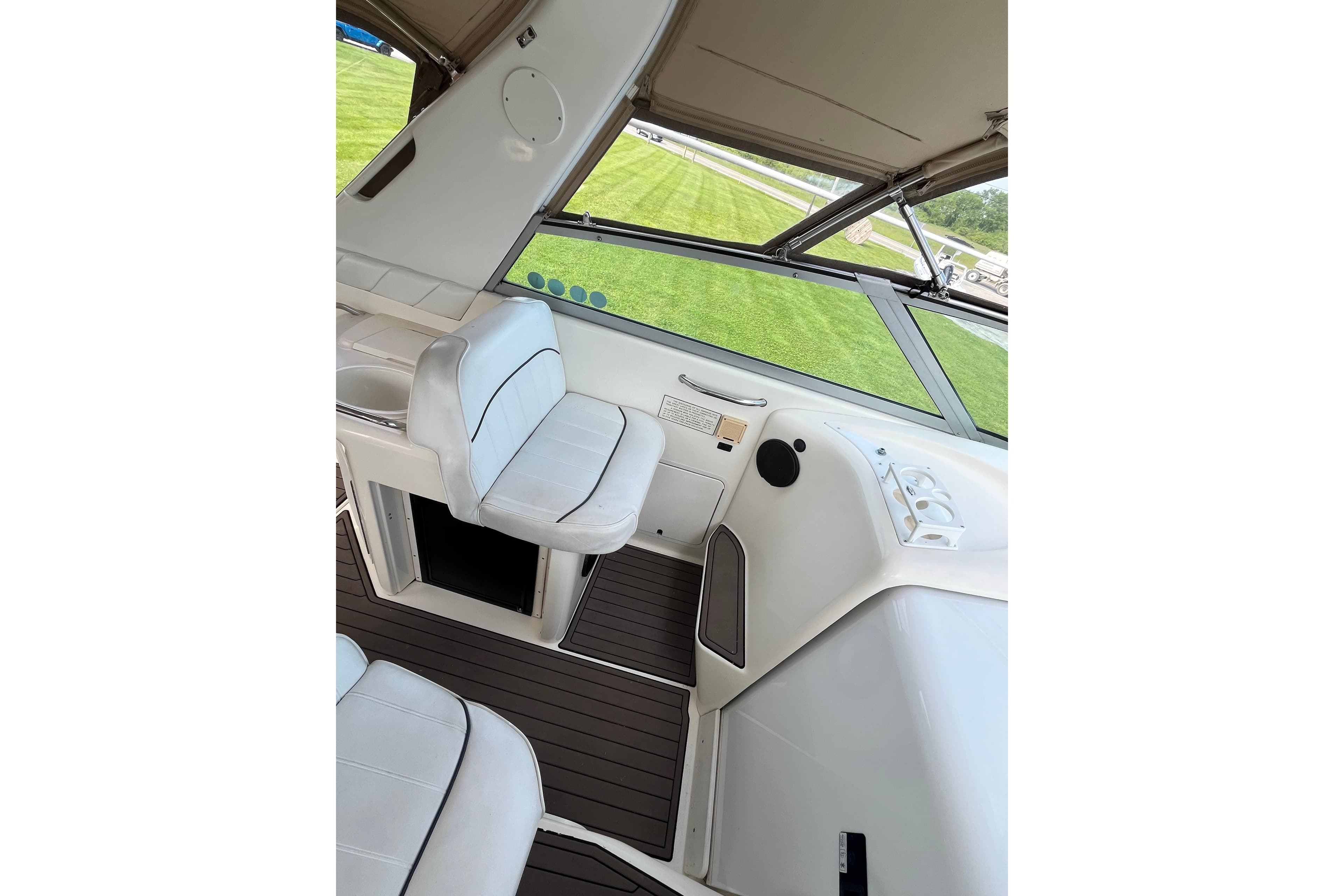 1995 Sea Ray Sundancer 330 interior with white seating and dashboard view.