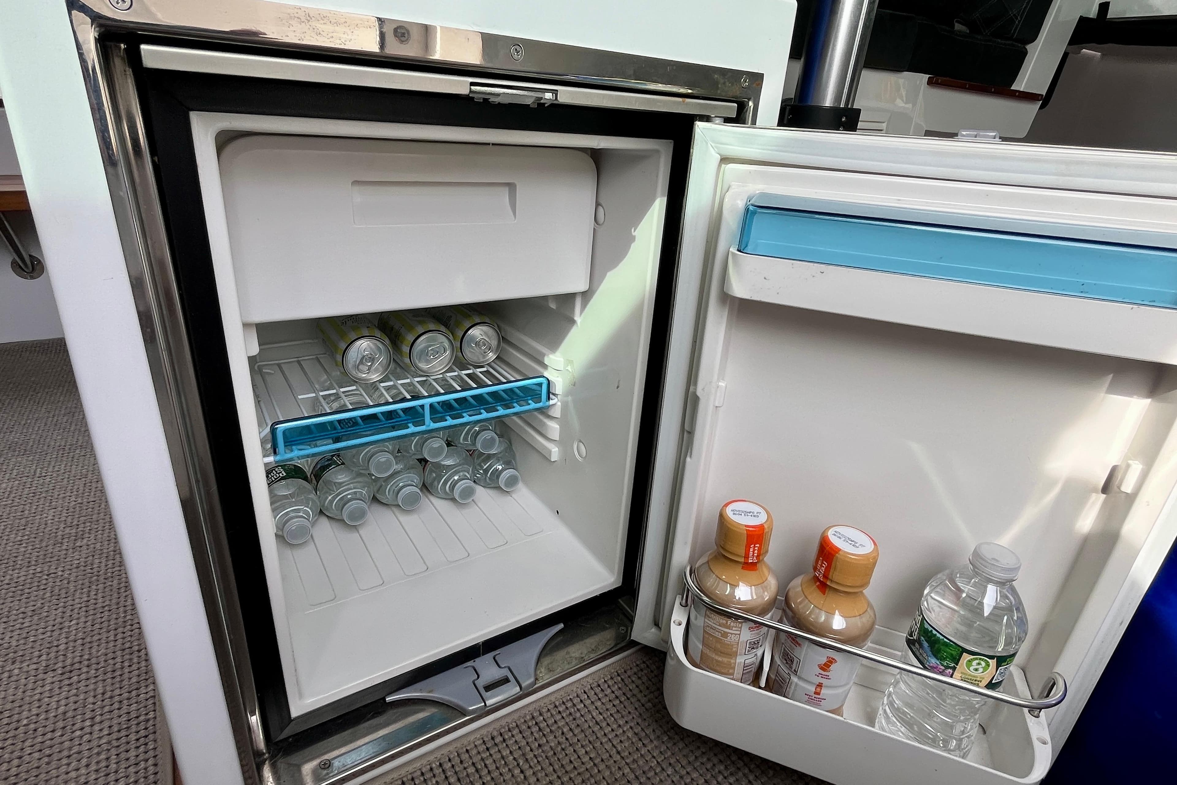 Mini fridge stocked with drinks inside a 2018 Axopar 37 Sport Cabin R boat.