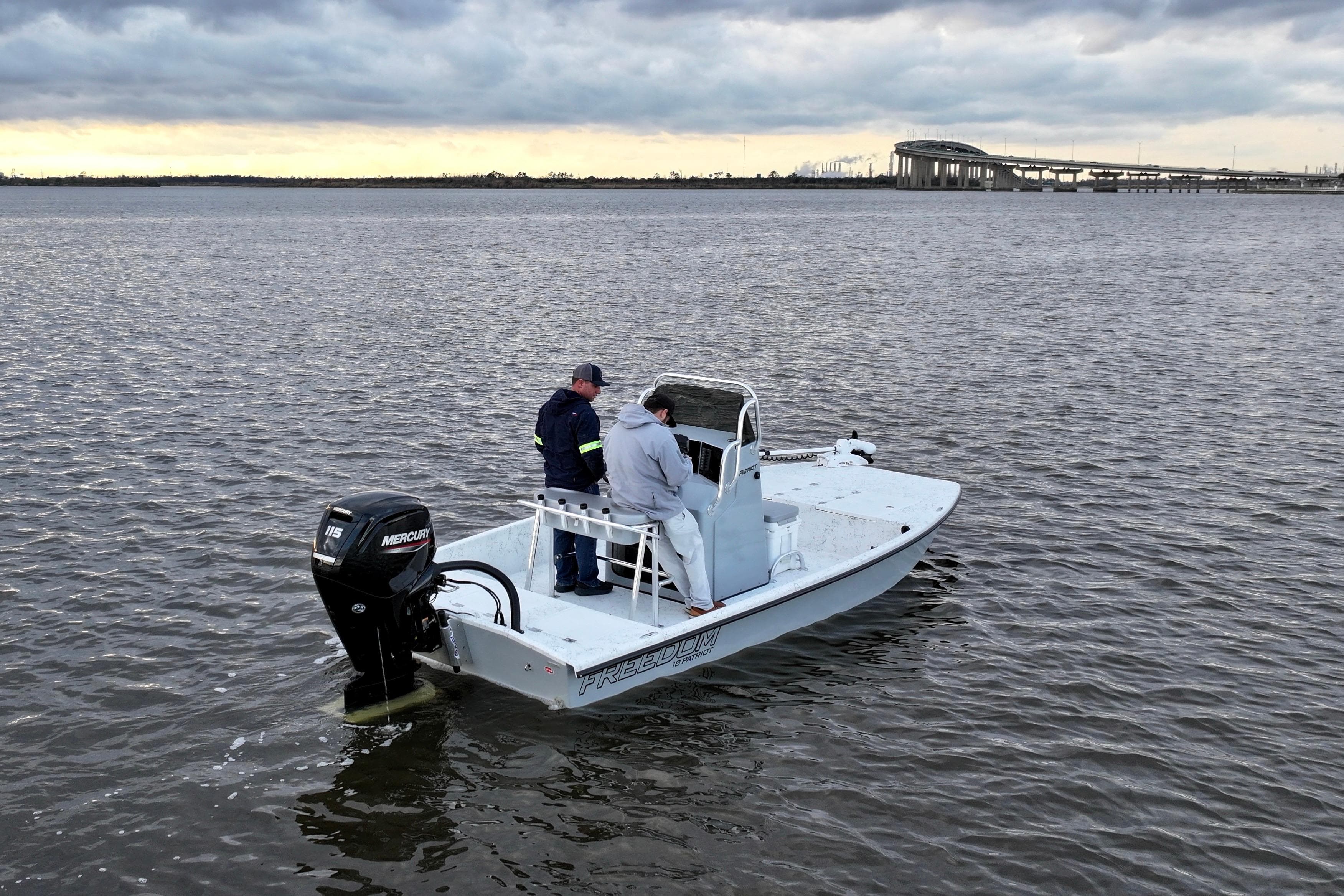 Freedom Boats 18' Patriot 2025 on calm water under cloudy sky.