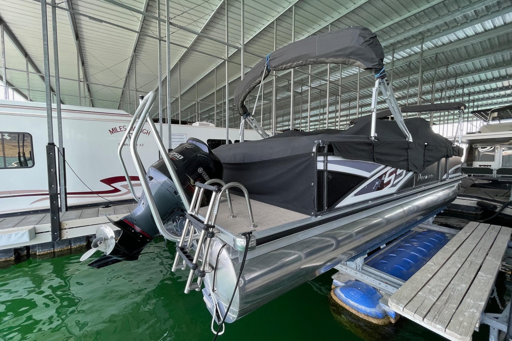 2014 Premier Yachts 250 S-Series RF pontoon boat docked under a covered marina.