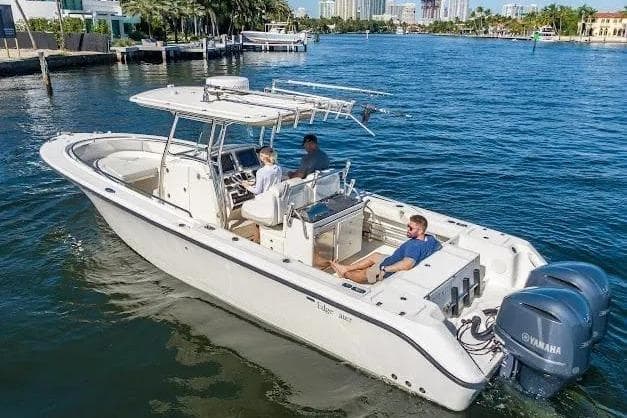 2010 Edgewater 318CC boat cruising on a sunny day with three passengers.