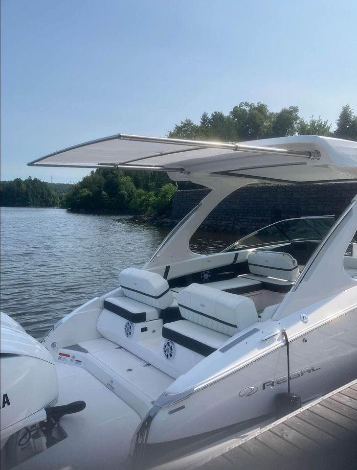 2024 Regal 29 OBX boat docked by a serene lake with lush greenery.