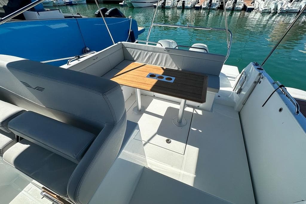 2024 Beneteau Flyer 9 SUNdeck boat interior with seating and table, docked in marina.