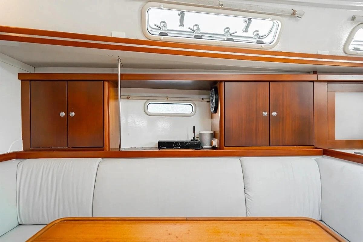 Interior of 2011 Hanse 400 yacht with wooden cabinets and white seating.
