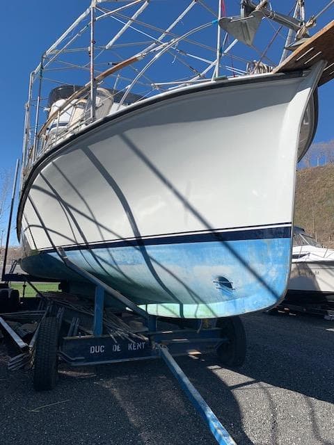 1985 Custom Cape Island Trawler 43 on trailer, blue and white hull, outdoor setting.