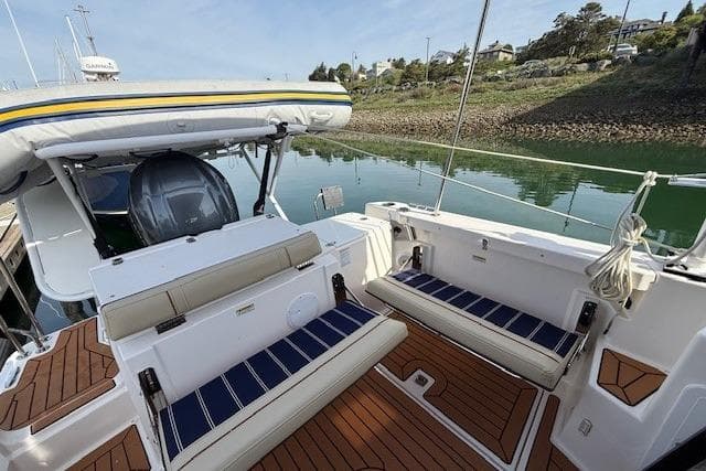 2023 Ranger Tugs R-27 boat with spacious deck and seating, docked by calm waters.