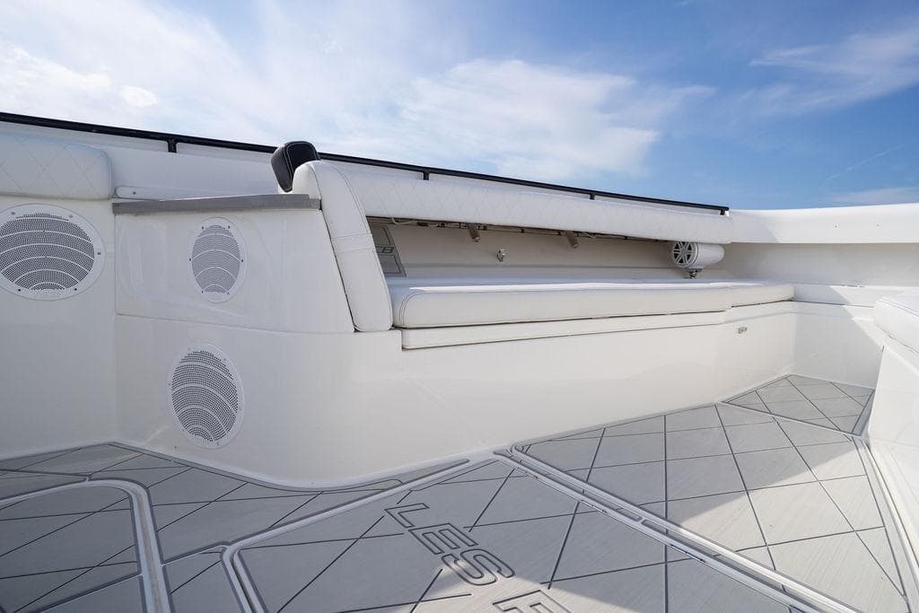 2019 HCB 53 boat interior with cushioned seating and speakers under a blue sky.