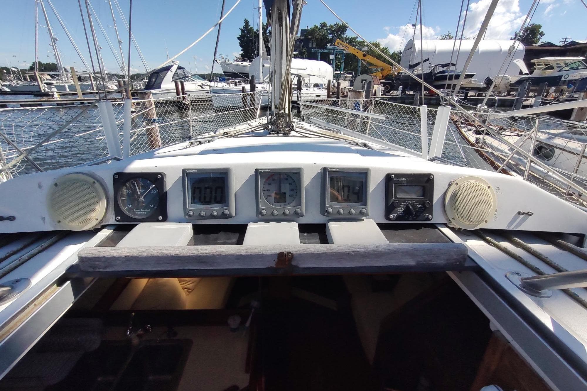 Cockpit view of 1987 Hunter 37 Legend sailboat with navigation instruments and marina background.