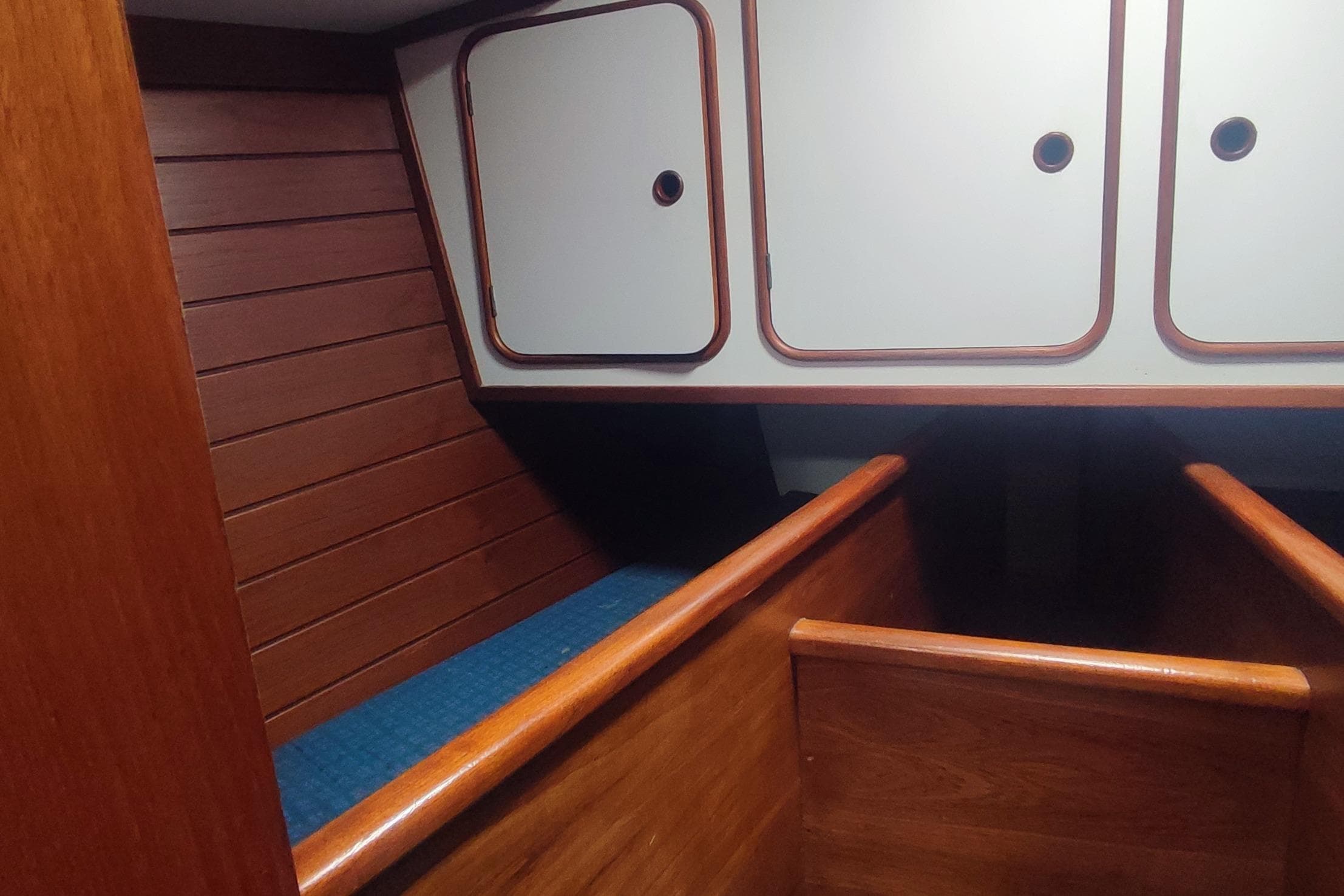 Interior of 1987 Custom Danish 44 boat with wooden paneling and storage cabinets.