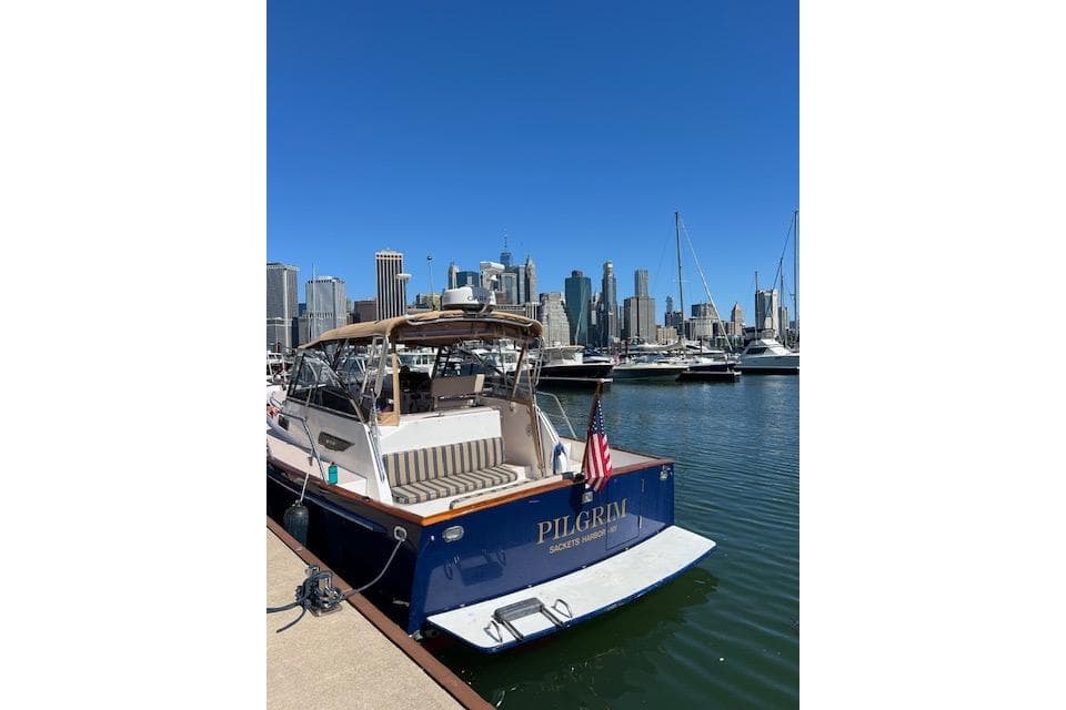 2001 Legacy Yachts Express docked with city skyline in background.