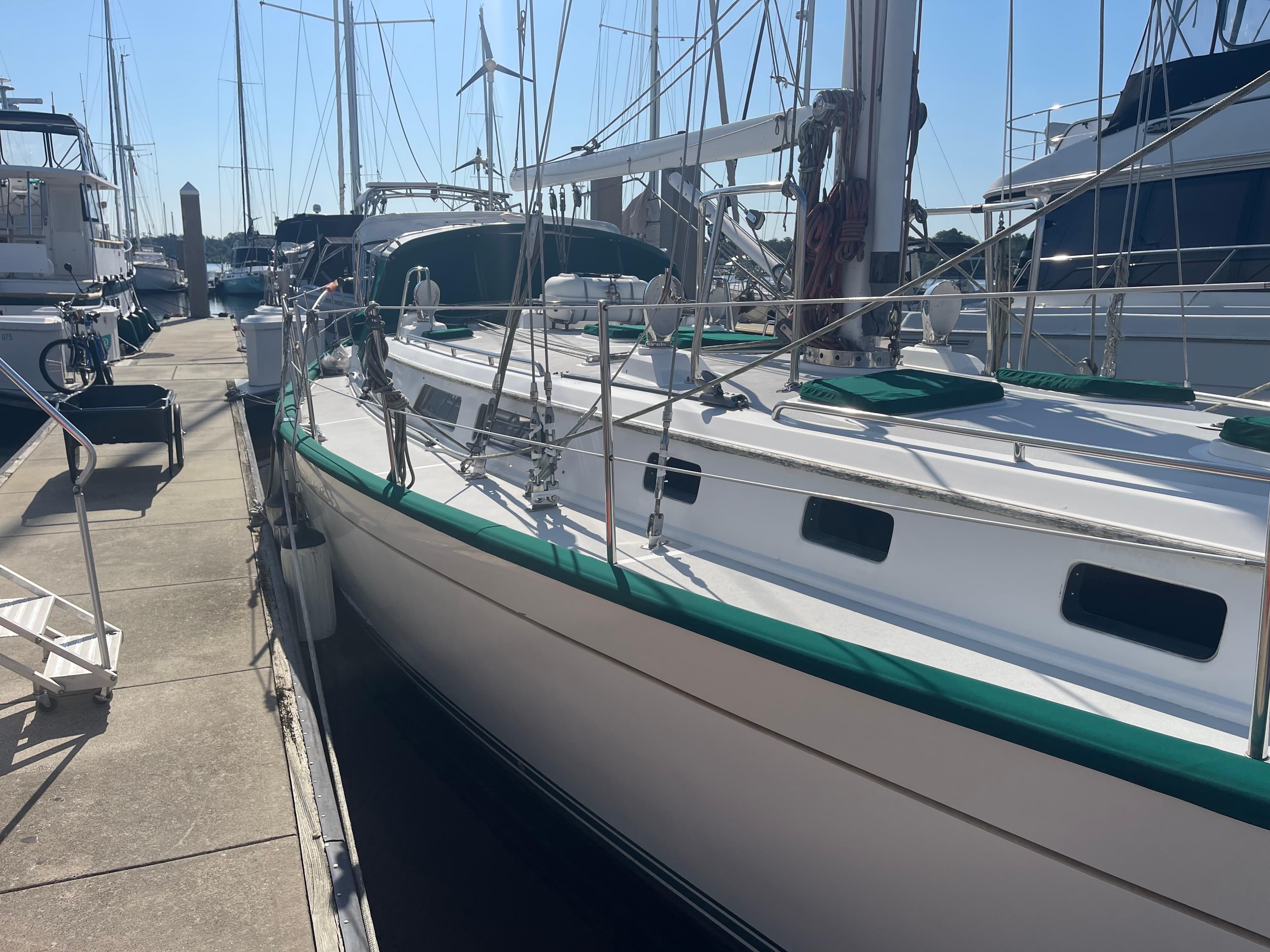 Sailboat Passport 47 AC Plan B 1995 docked at marina, side view.