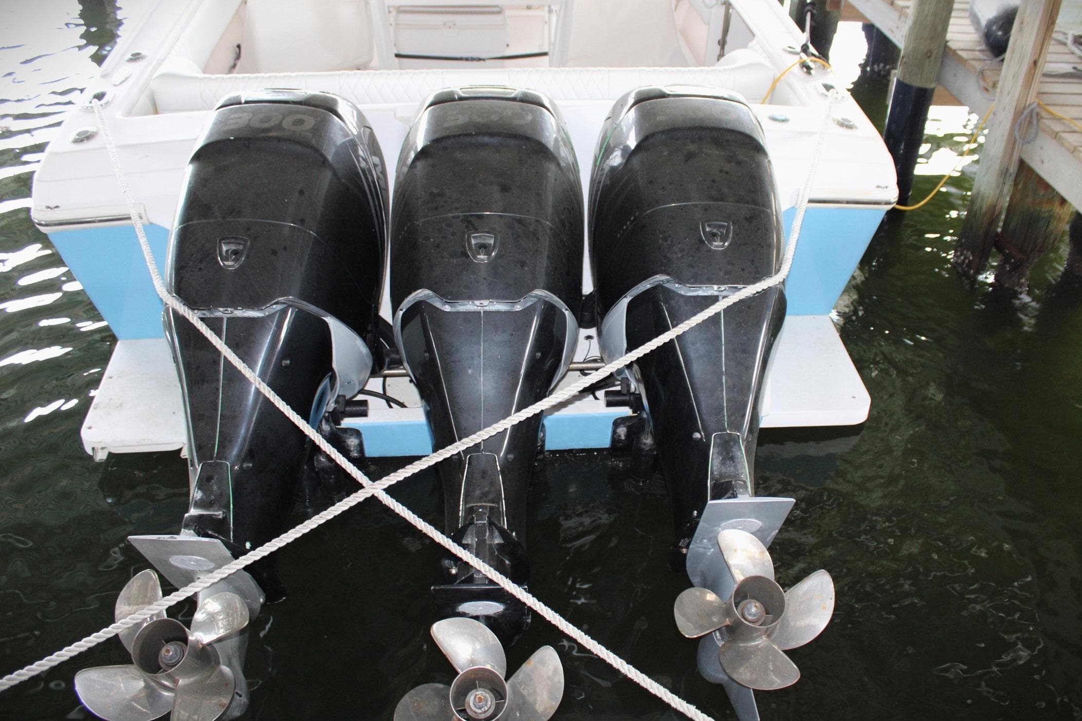 2001 Intrepid 366 boat with triple outboard engines docked in water.