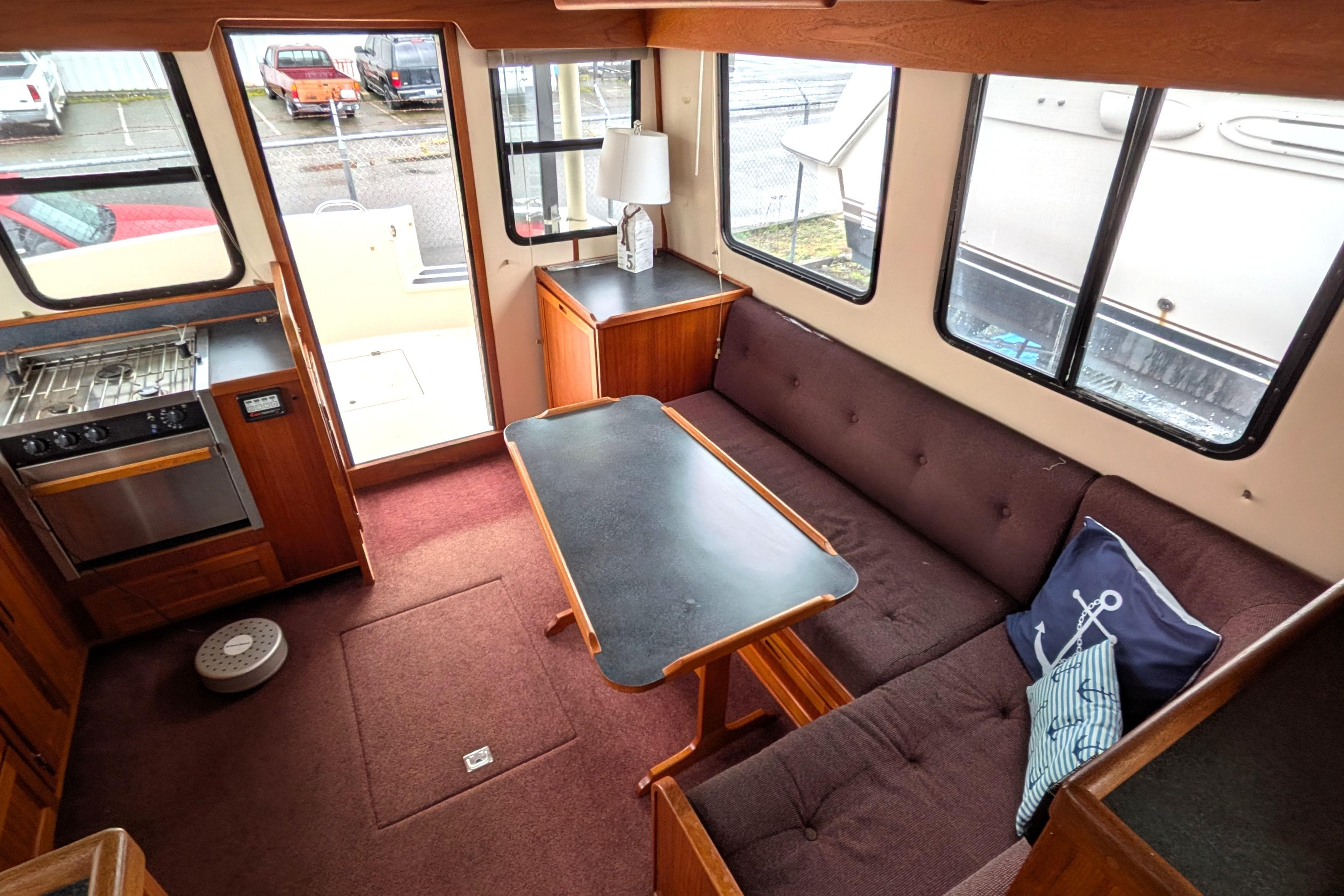 Interior of a 2000 Nordic Tug 37, featuring a cozy dining area and compact kitchen.