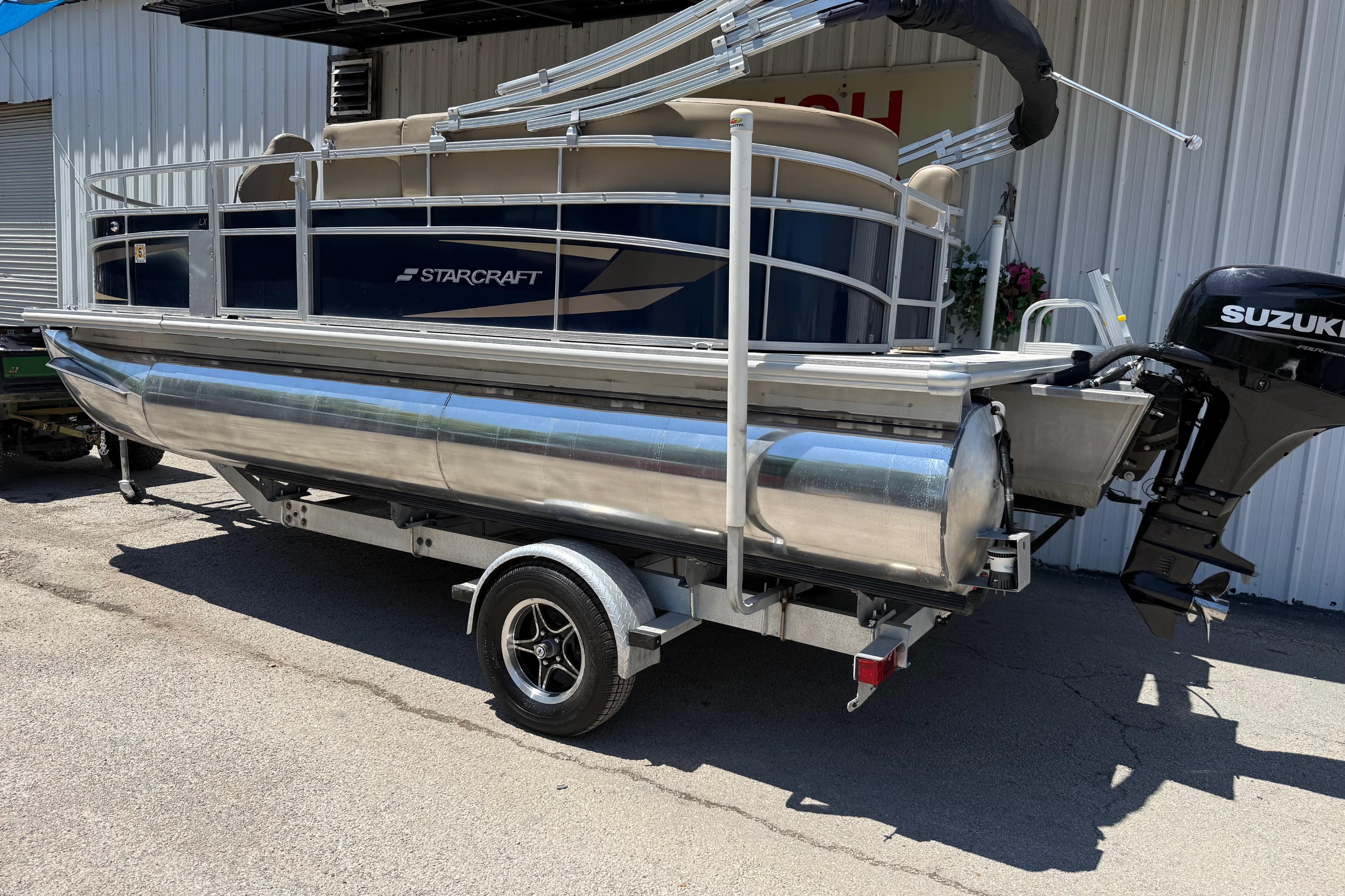 2023 Starcraft LX 18 F pontoon boat on trailer with Suzuki outboard motor.
