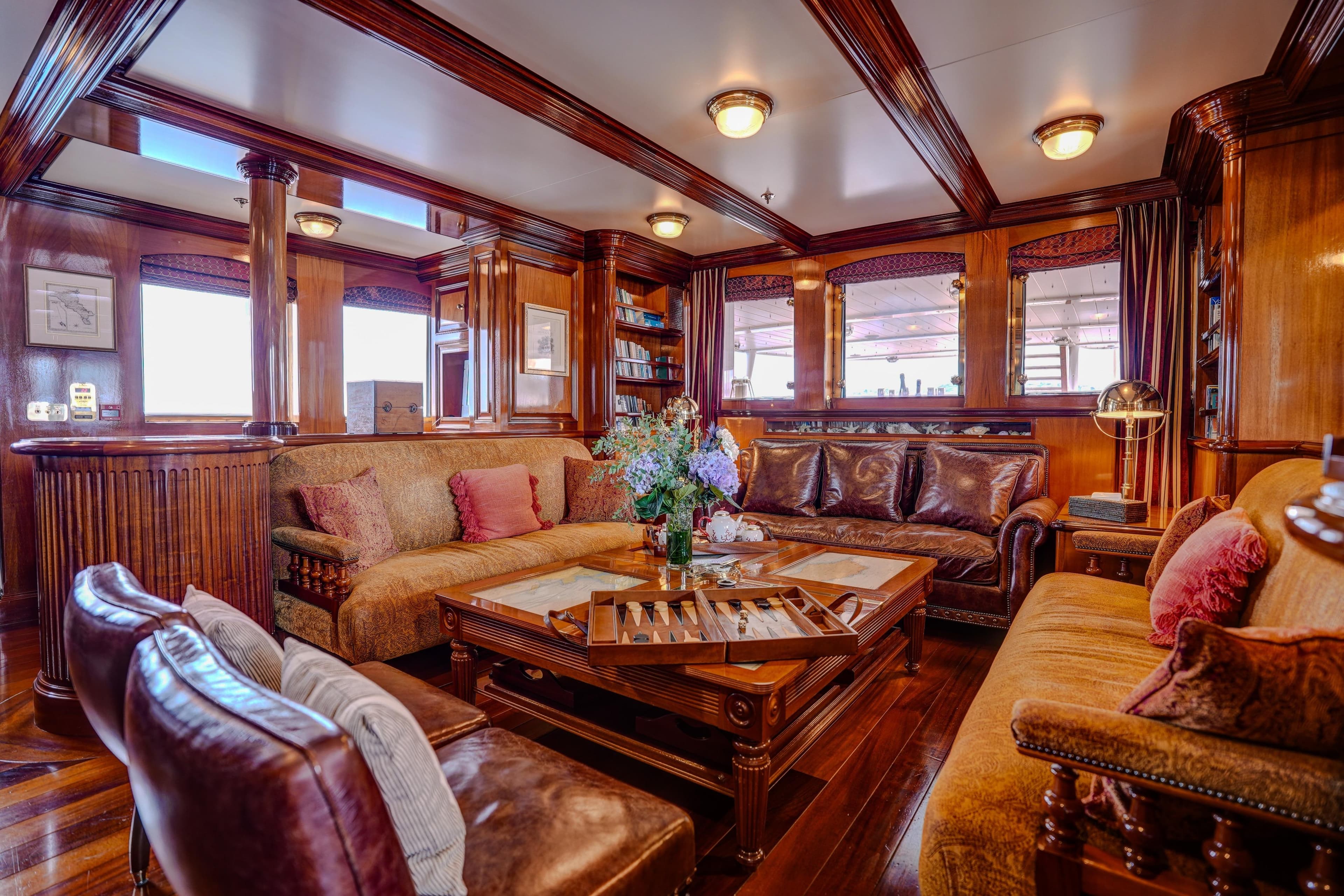 Luxurious Pendennis 55 yacht interior, 2009 model, featuring elegant wood paneling and plush seating.