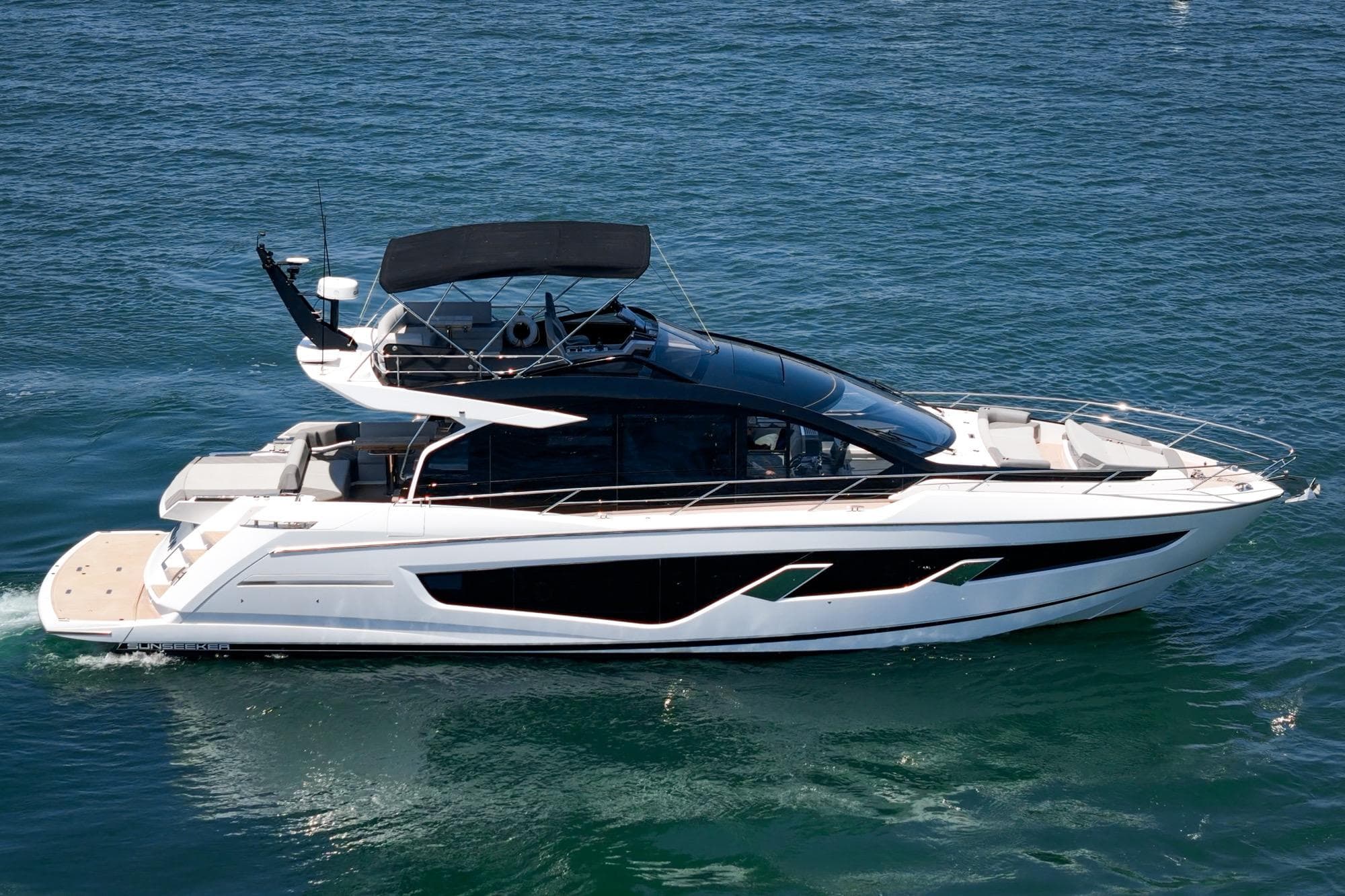 2023 Sunseeker 65 Sport Yacht cruising on clear blue water.