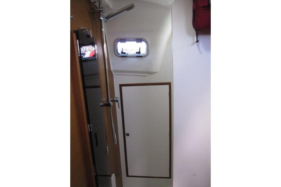 Interior of 2022 Jeanneau Sun Odyssey 349 sailboat, featuring a compact bathroom with shower.