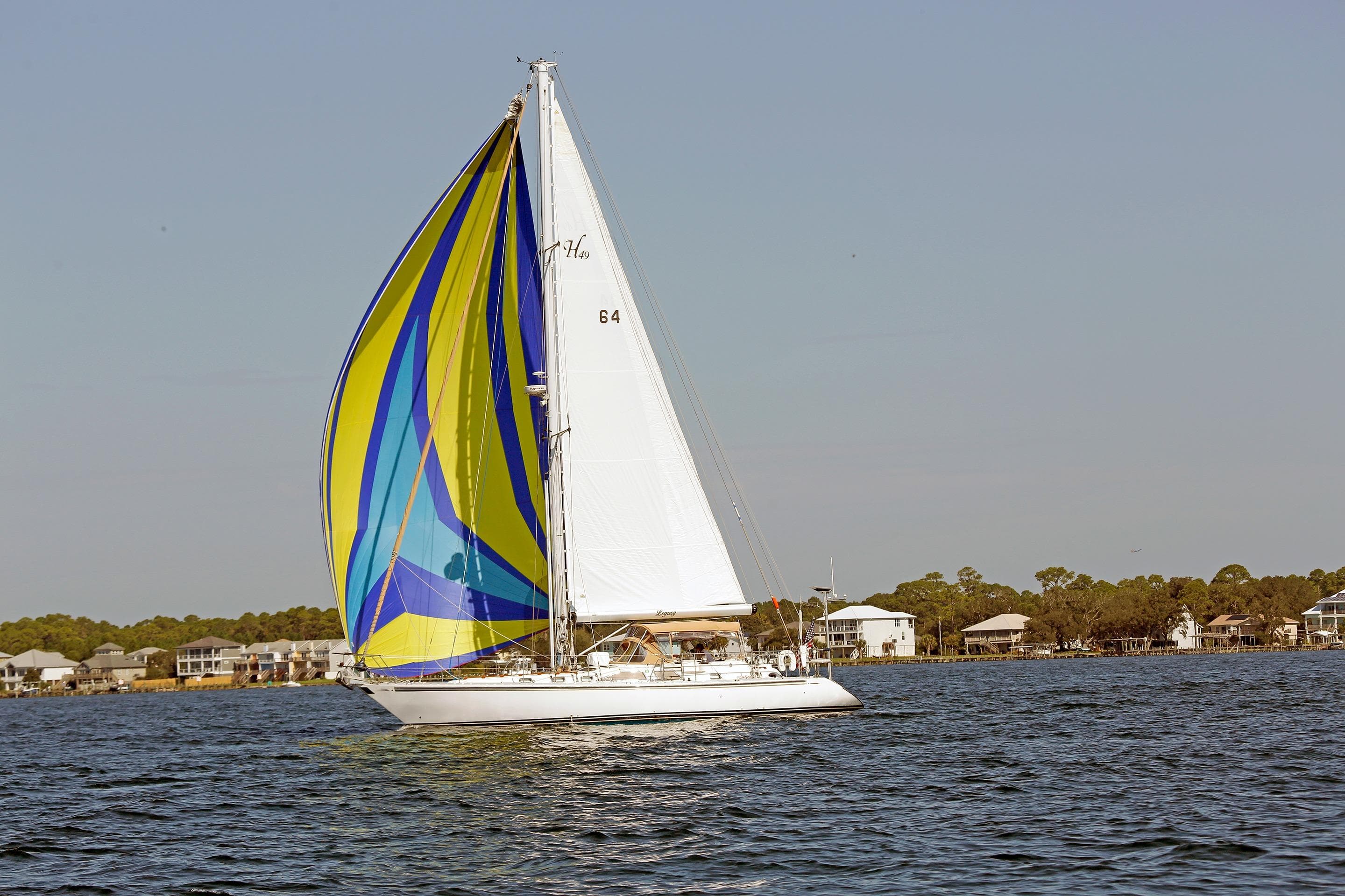 Sailing yacht Hylas 49CC 2012 with colorful spinnaker on calm water.