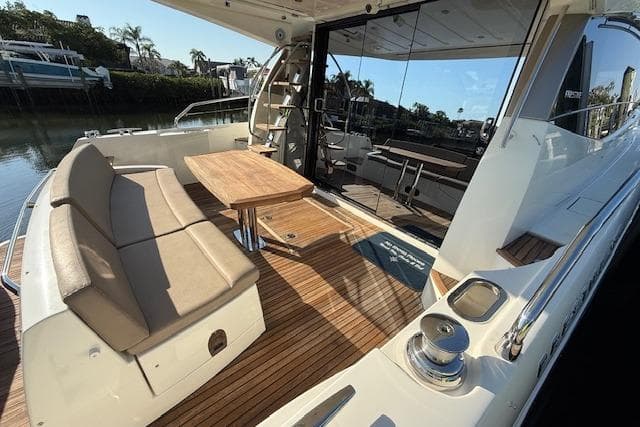 Luxurious 2015 Prestige 500 yacht with spacious deck, seating, and wooden table.