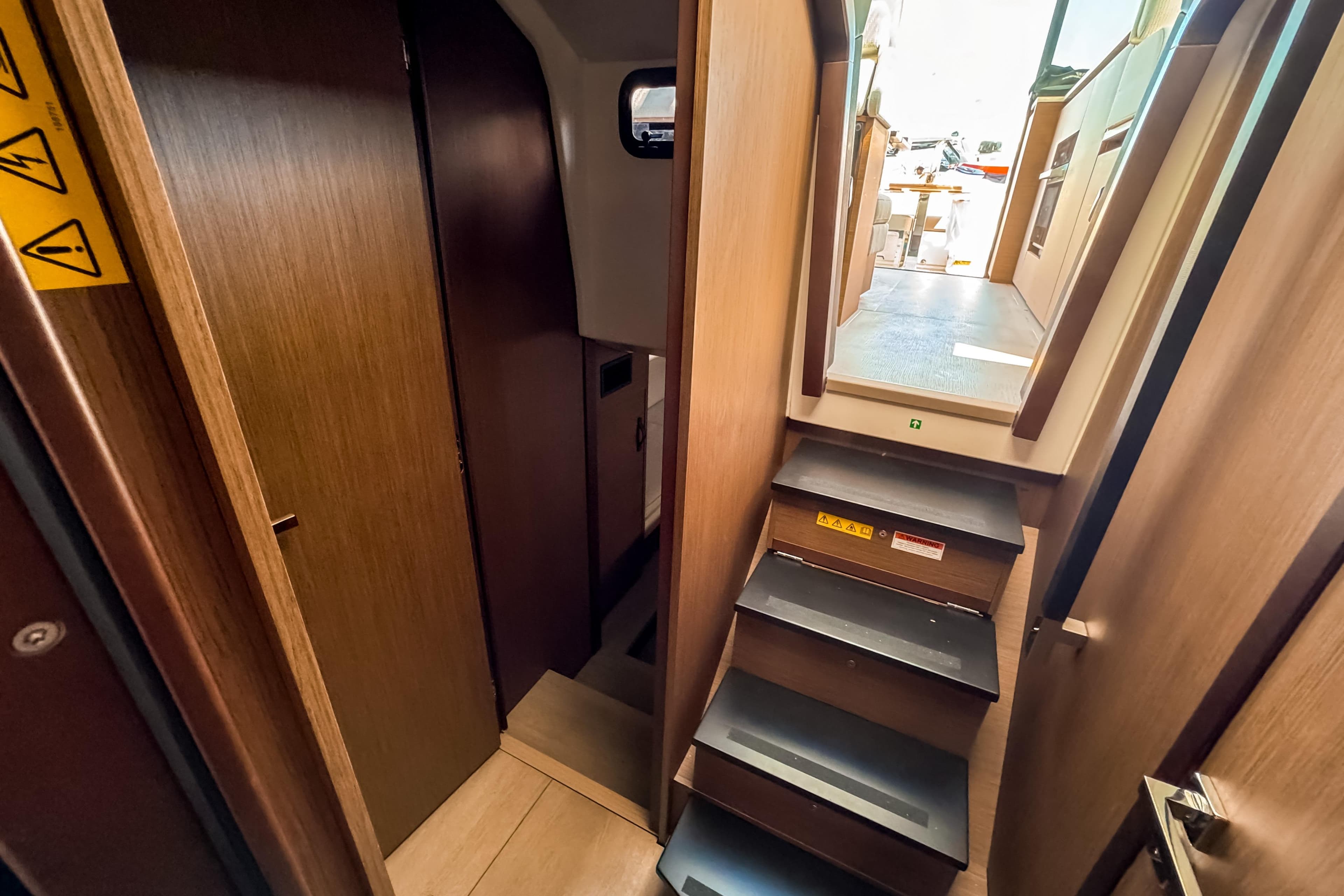 Interior of 2026 Wellcraft 44 Explorer with stairs and wooden walls.