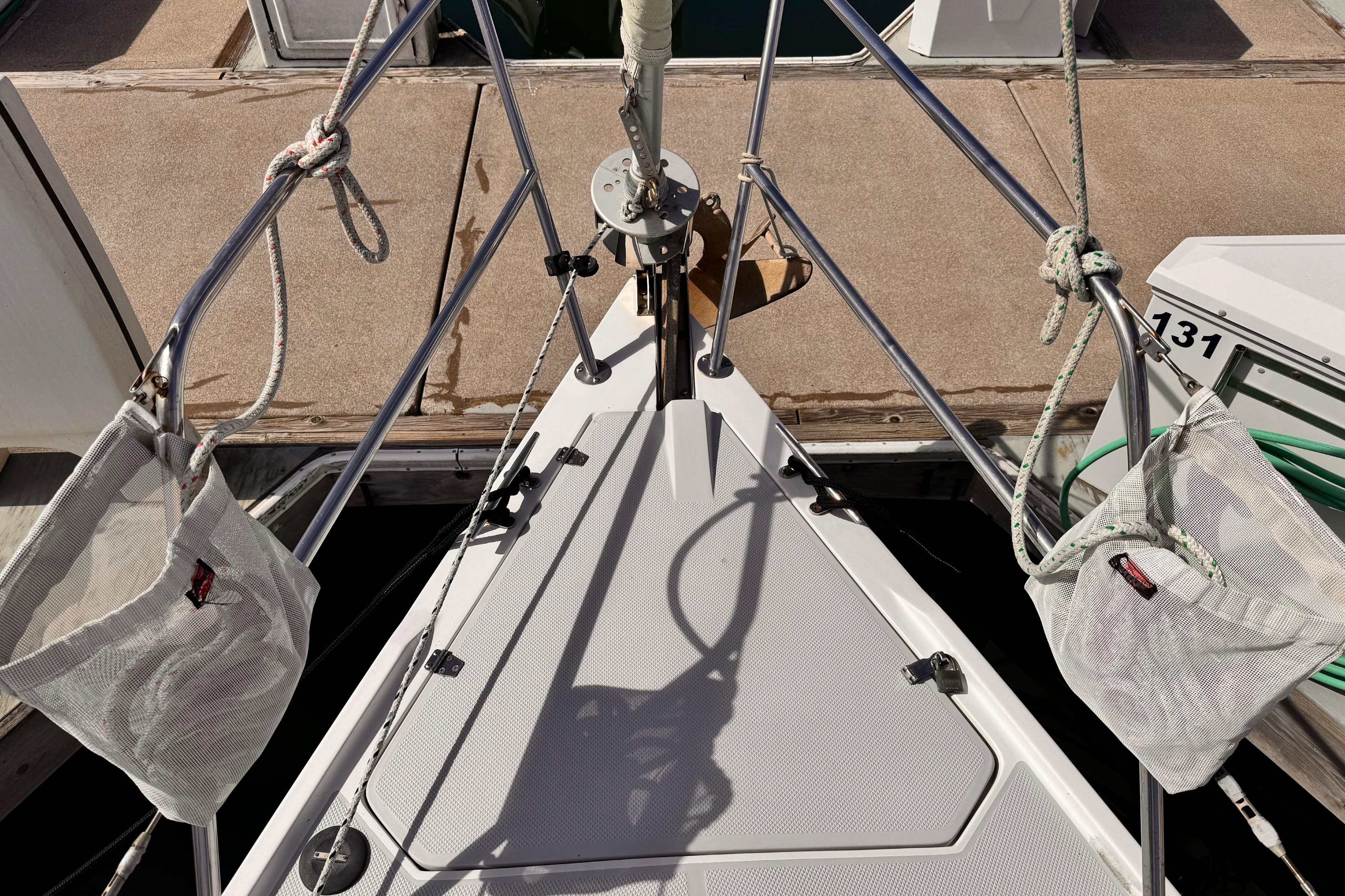 Bow of a 1995 Catalina 36 MkII sailboat docked, featuring ropes and deck details.