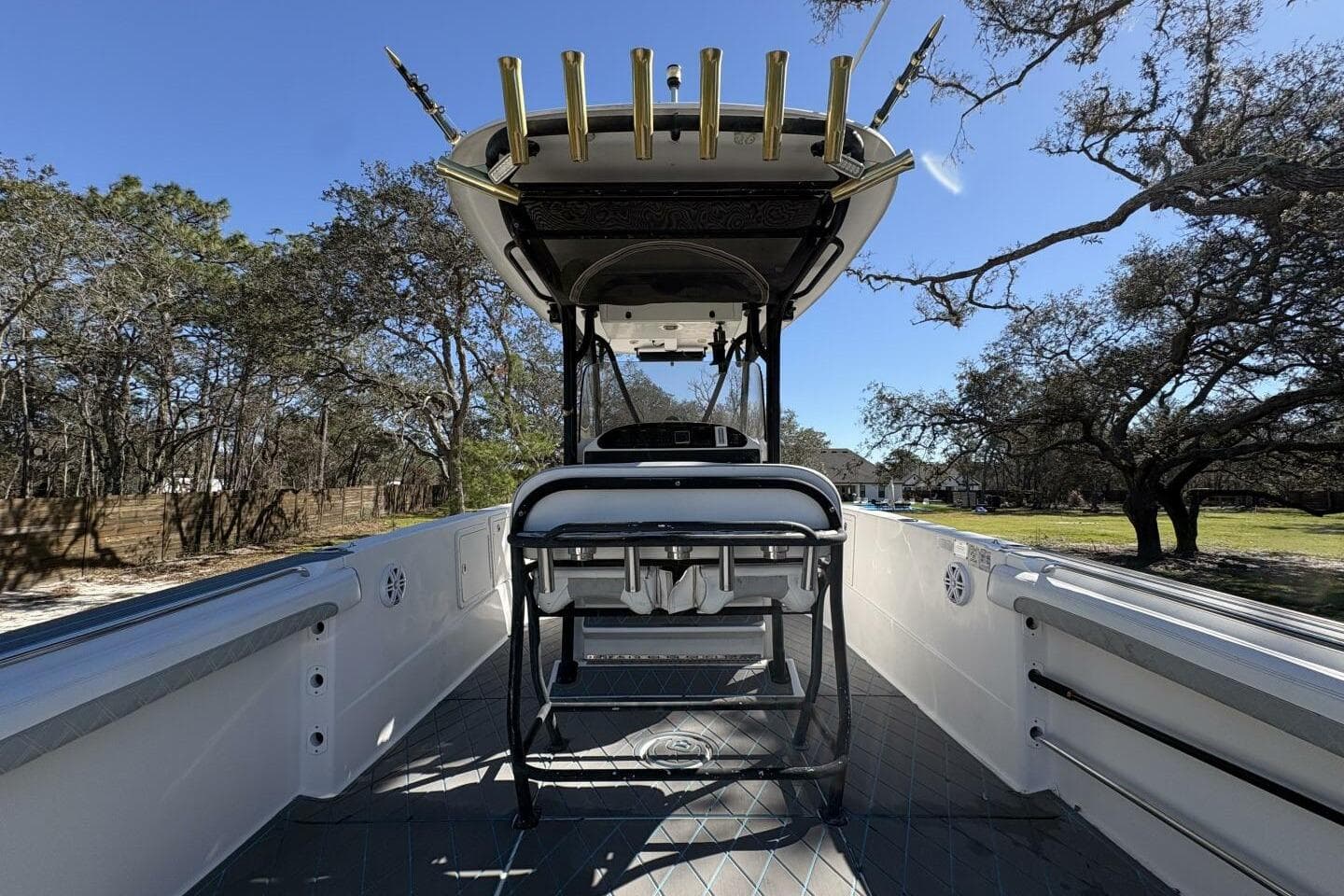 2008 Wellcraft 35 Scarab Sport boat interior with rod holders, surrounded by trees.