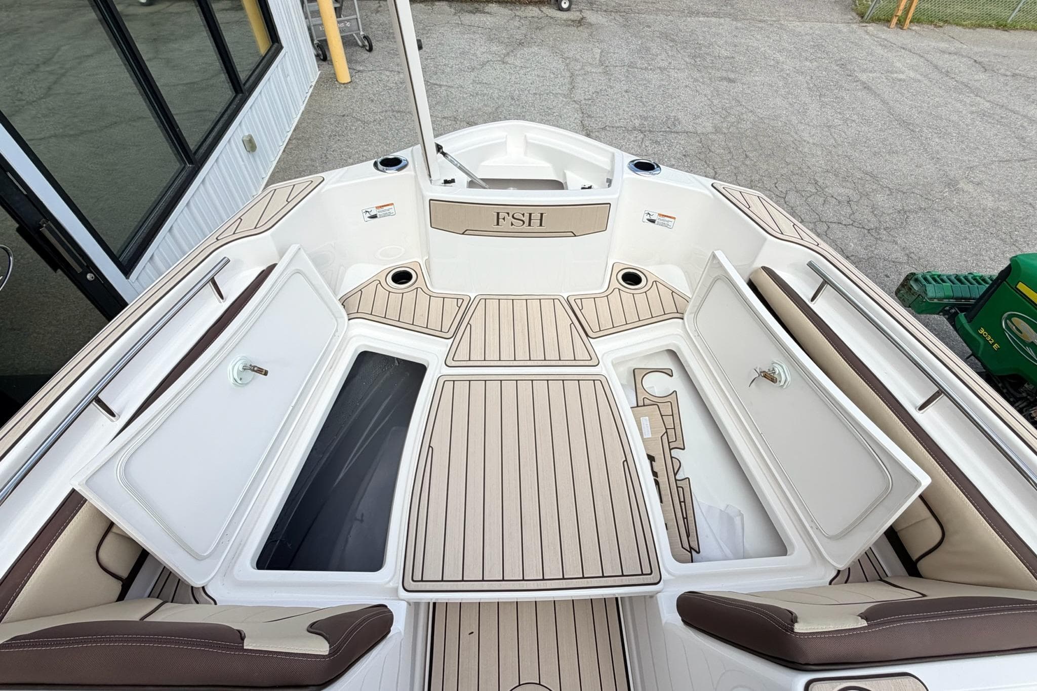 2026 Yamaha Boats 255 FSH Sport H deck with storage compartments open, showcasing sleek design.