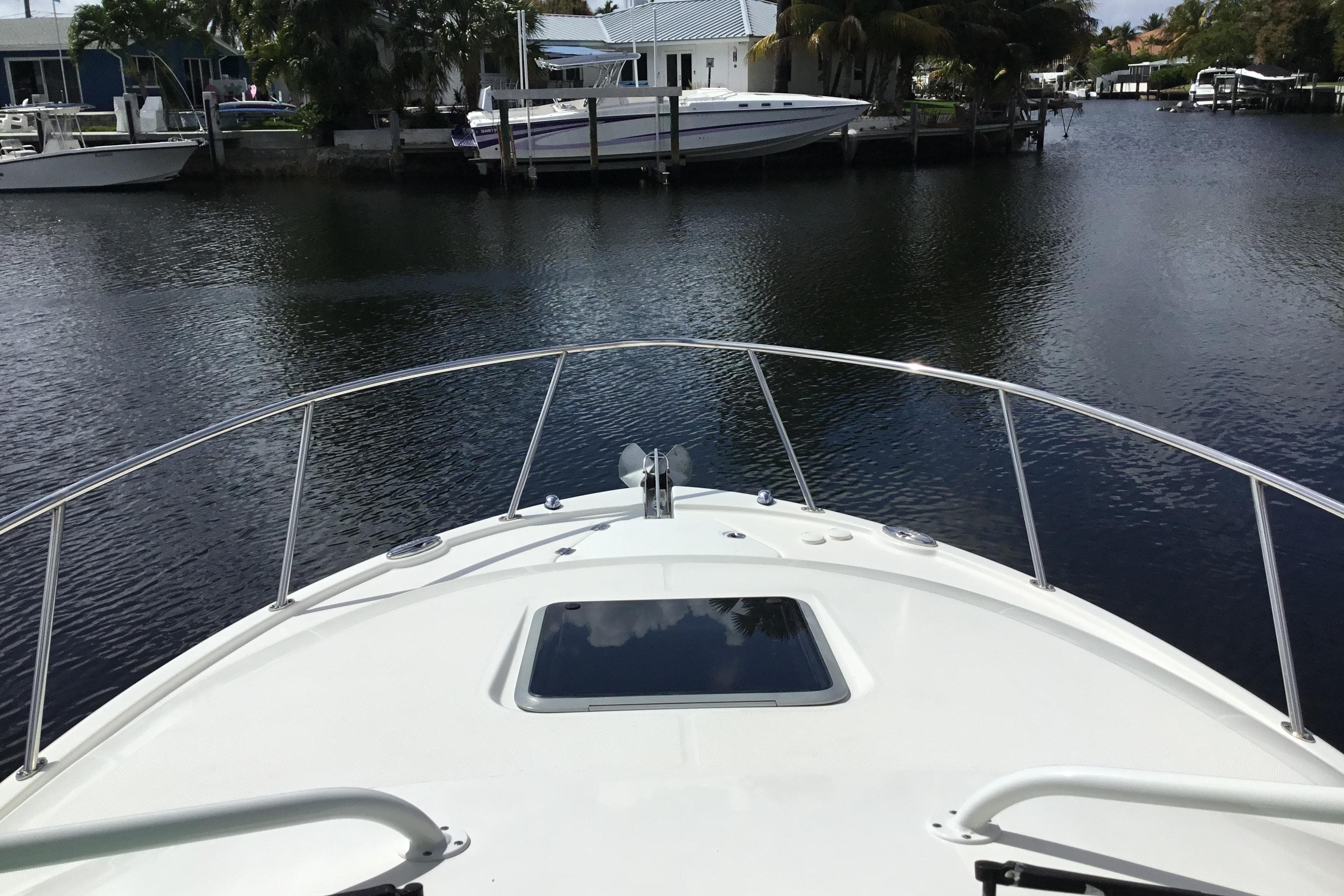 2017 Robalo R305 Walkaround boat on calm water near docks and houses.