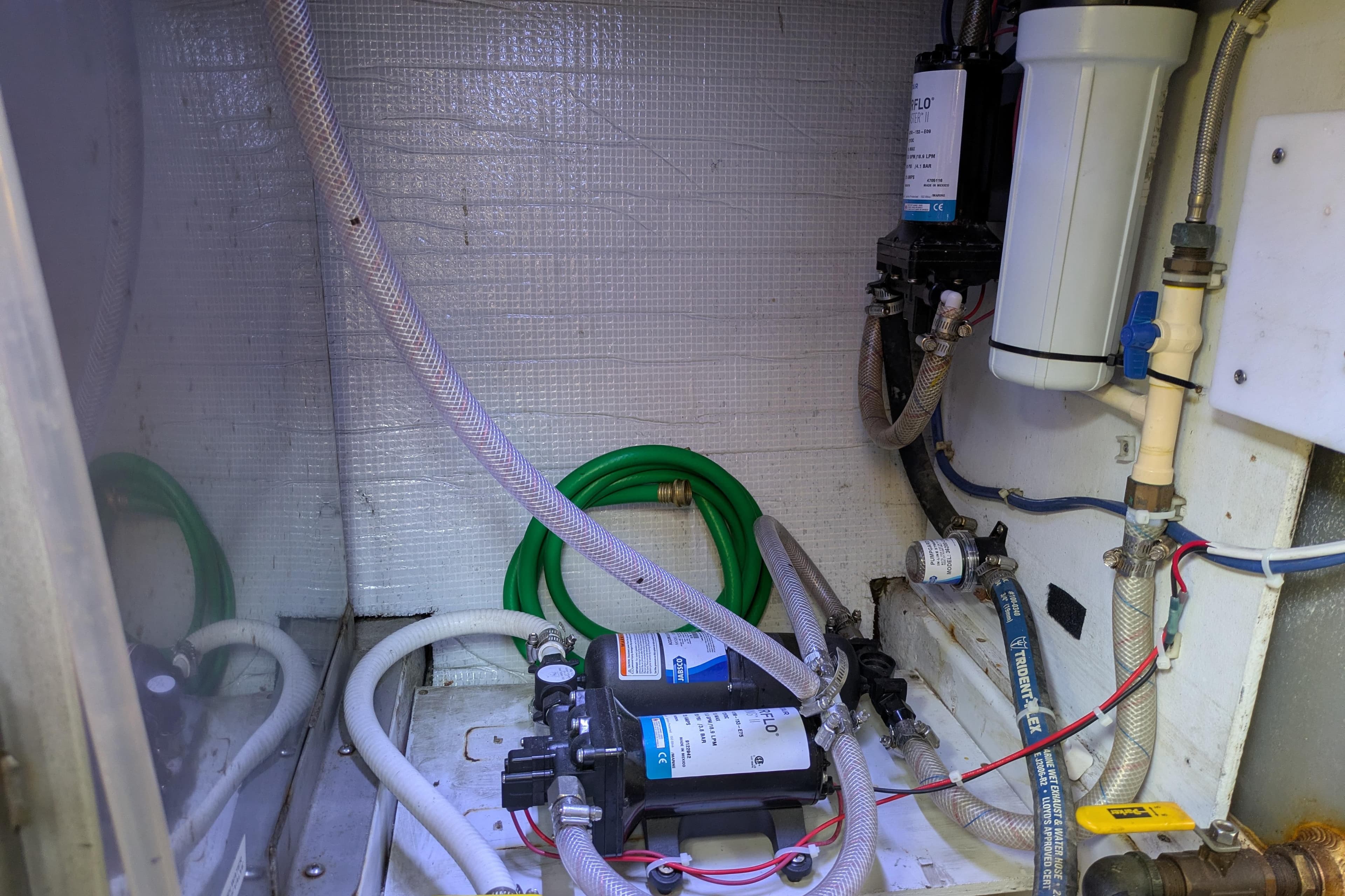 Engine room of a 2005 American Tug 41 with visible hoses and equipment.