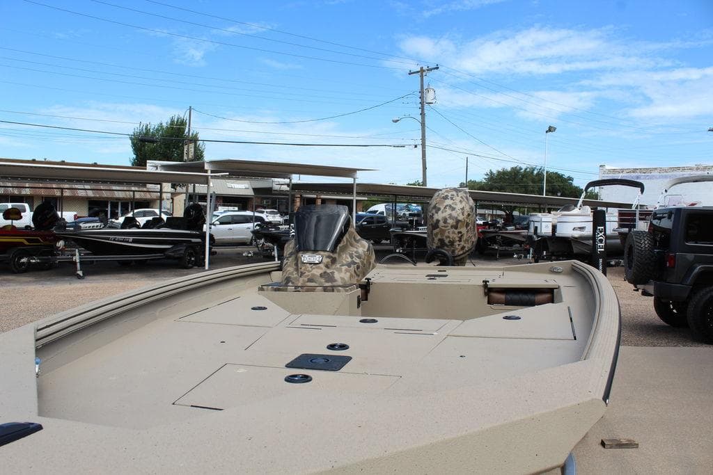 2026 Excel Bolt 183 boat displayed in outdoor showroom with other vehicles.