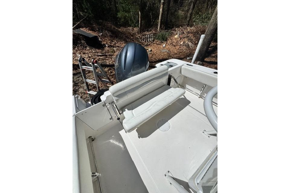 2021 Edgewater 208CC boat interior with seating and outboard motor in wooded area.