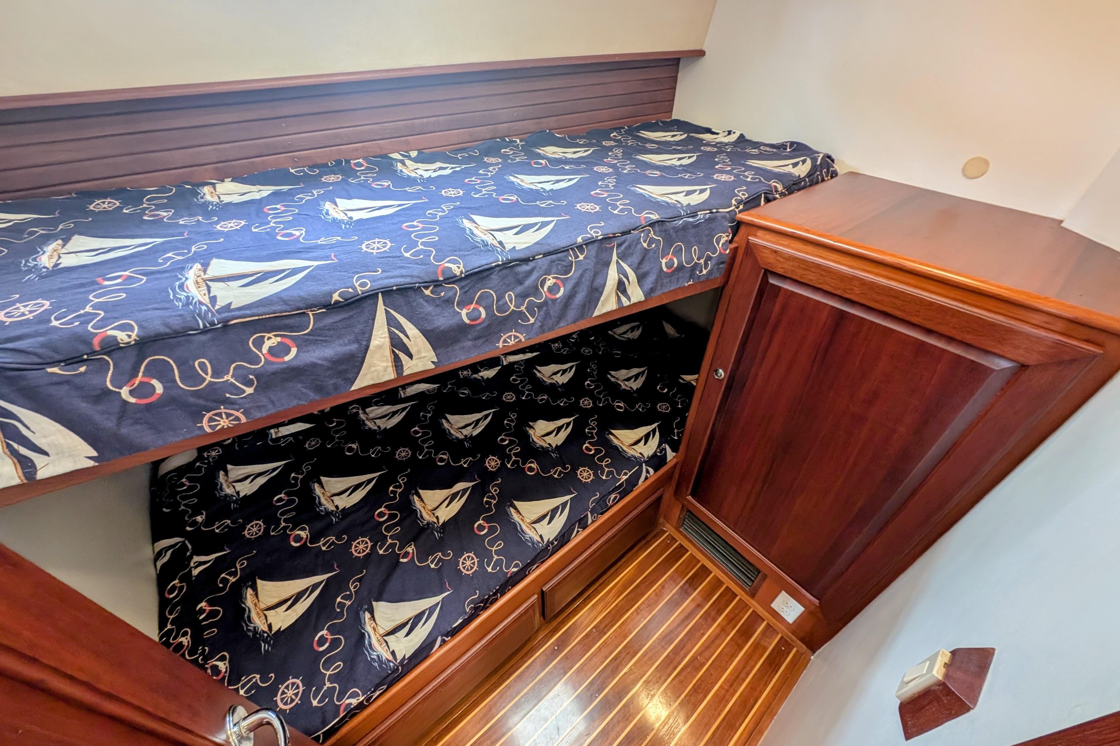 Bunk beds with nautical-themed bedding in 2002 Legacy Yachts 52 Express cabin.