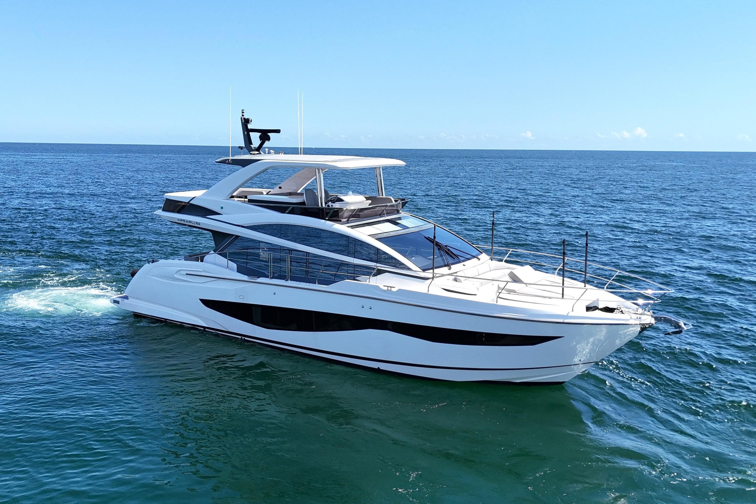 Luxurious 2022 Pearl 62 yacht cruising on open sea under clear blue sky.
